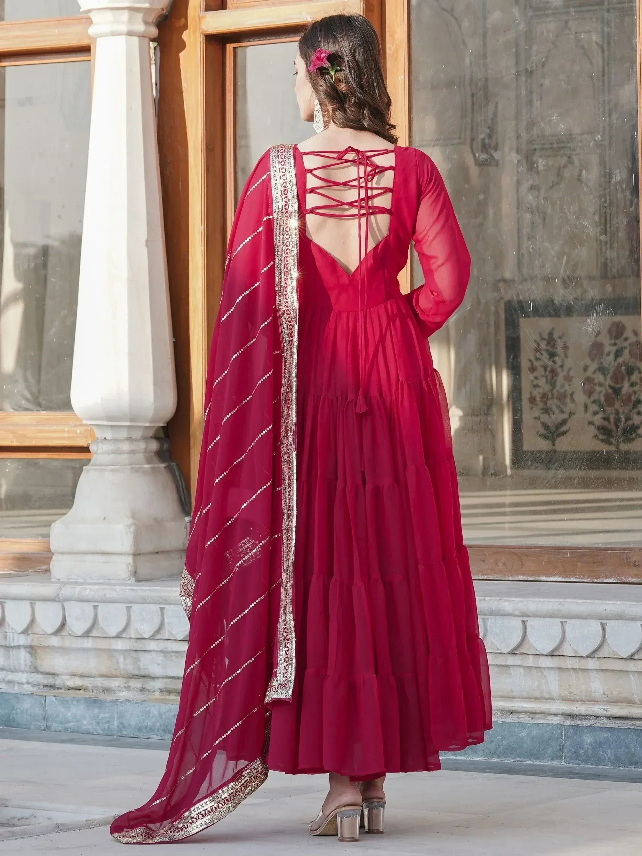 Red ethnic gown with lace-up back and embellished dupatta, perfect for Indian weddings or festive occasions.