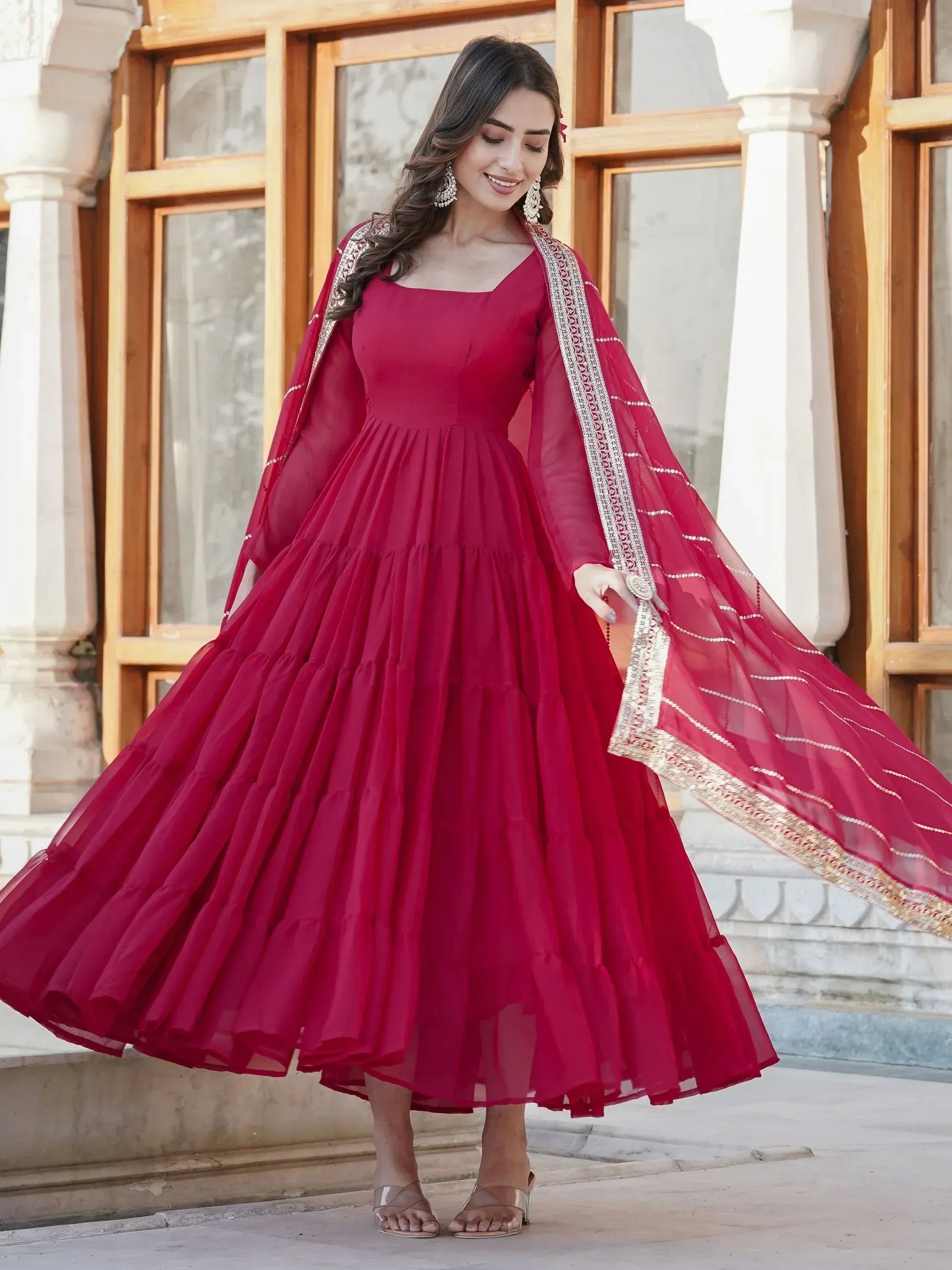 Elegant maroon ethnic gown with tiered skirt and embroidered dupatta for festive occasions