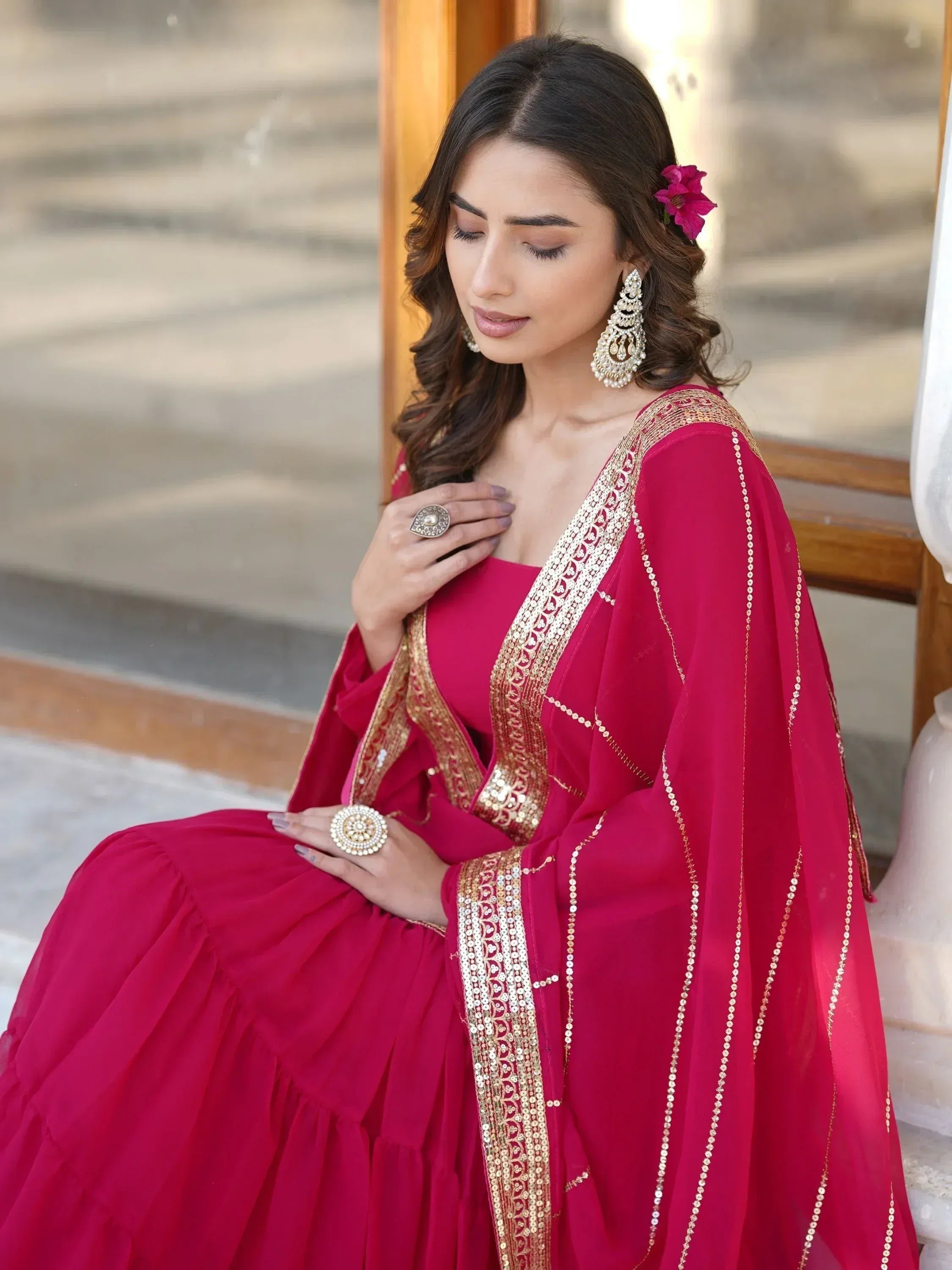Elegant woman in red ethnic gown with gold embroidery, perfect for Indian weddings and festive occasions.