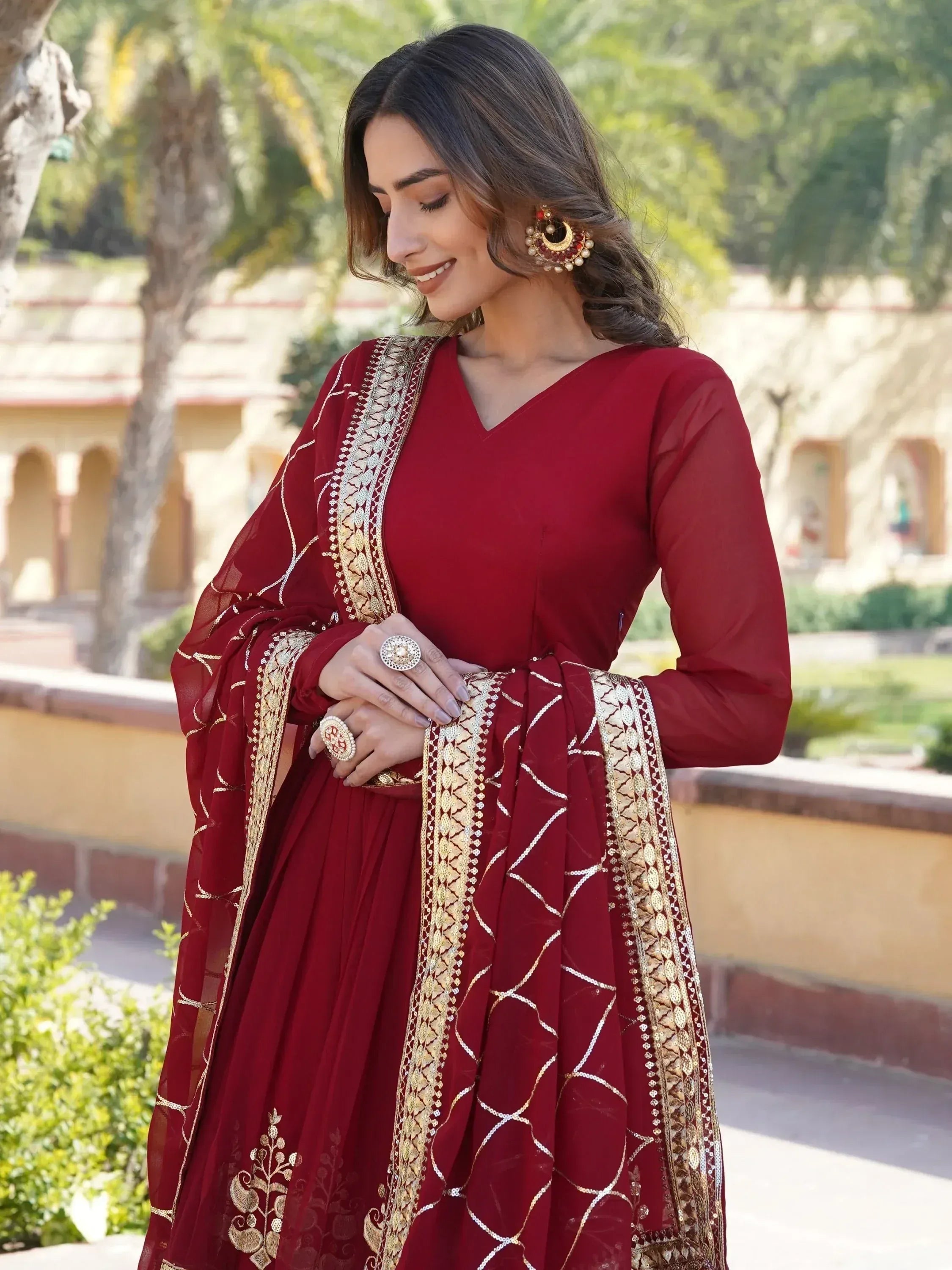 Maroon ethnic gown with gold embroidery, perfect for Indian weddings or festive occasions