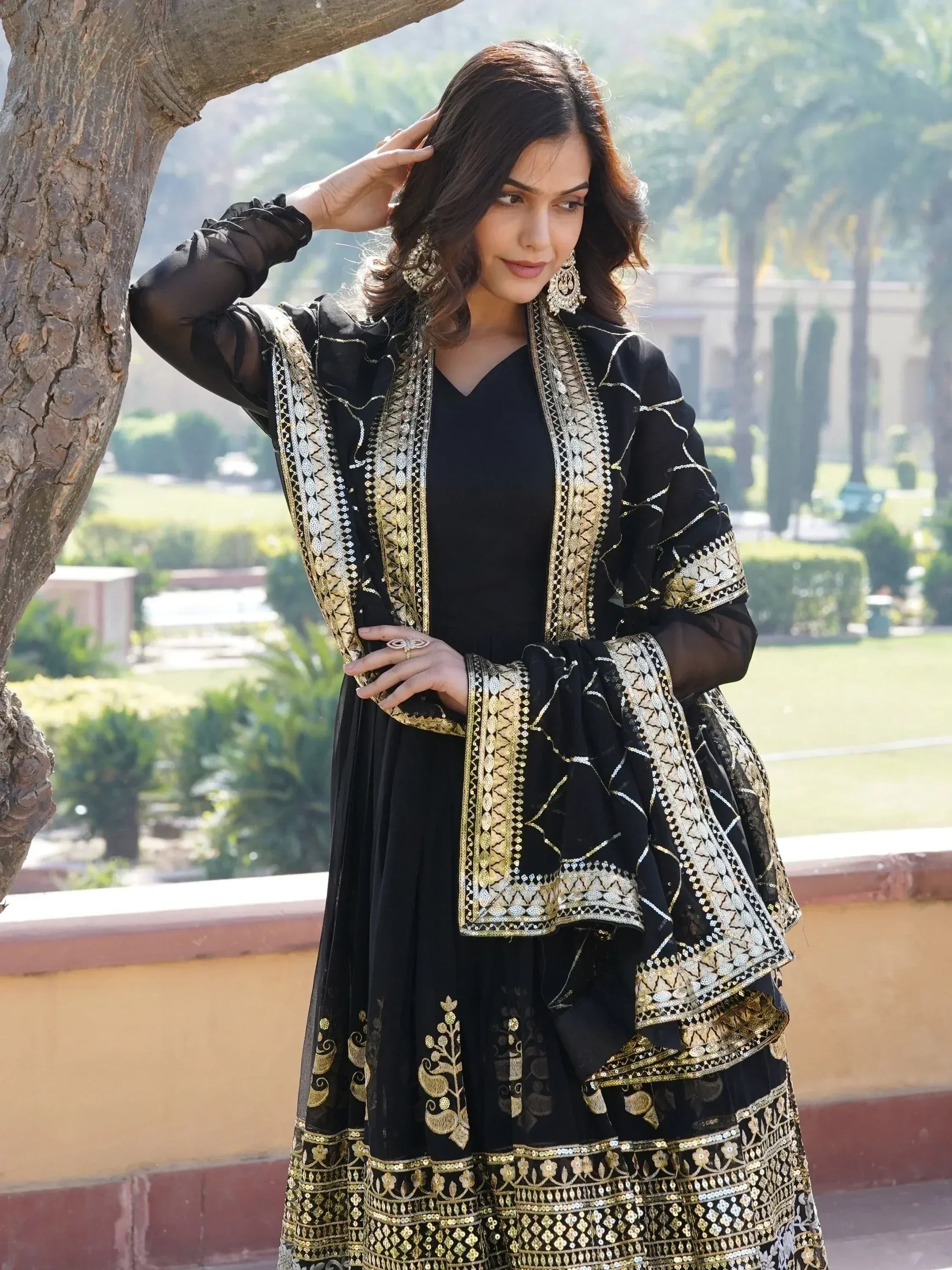 Black and gold embroidered Indian ethnic gown with sheer sleeves, perfect for festive occasions.