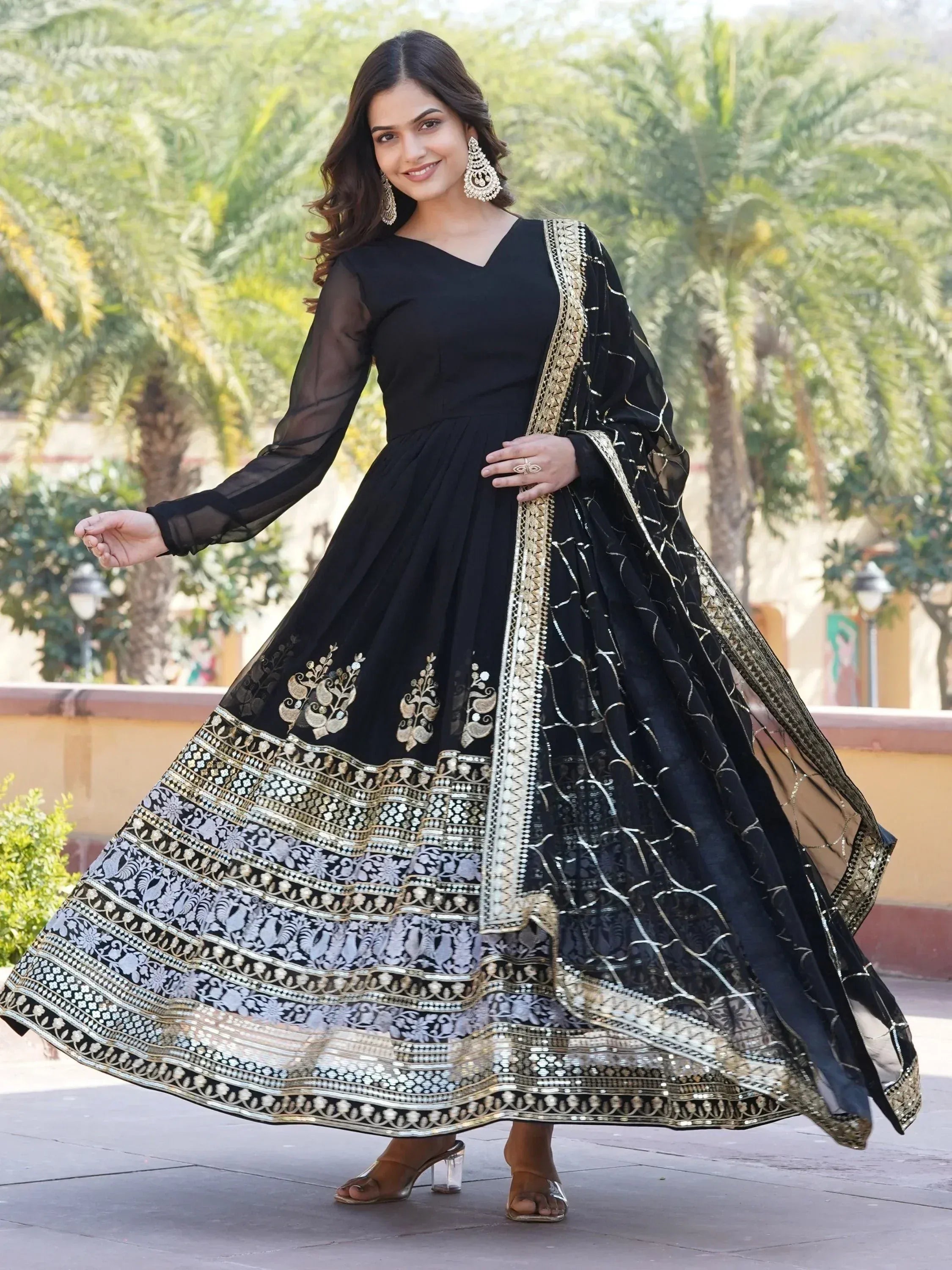 Black ethnic anarkali gown with gold embroidery and sheer sleeves, perfect for Indian festive occasions.
