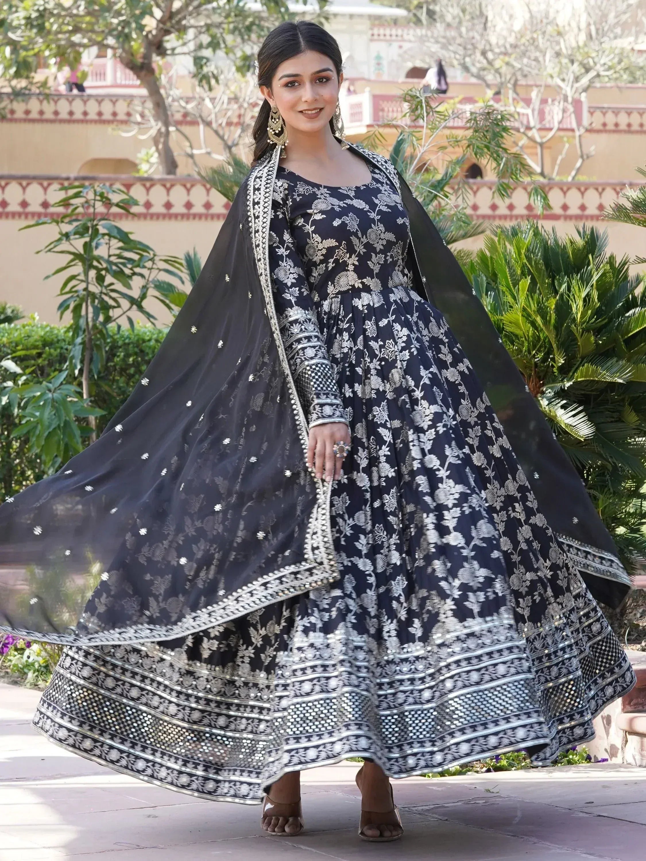 Woman wearing black and silver embroidered ethnic gown with dupatta, outdoor setting
