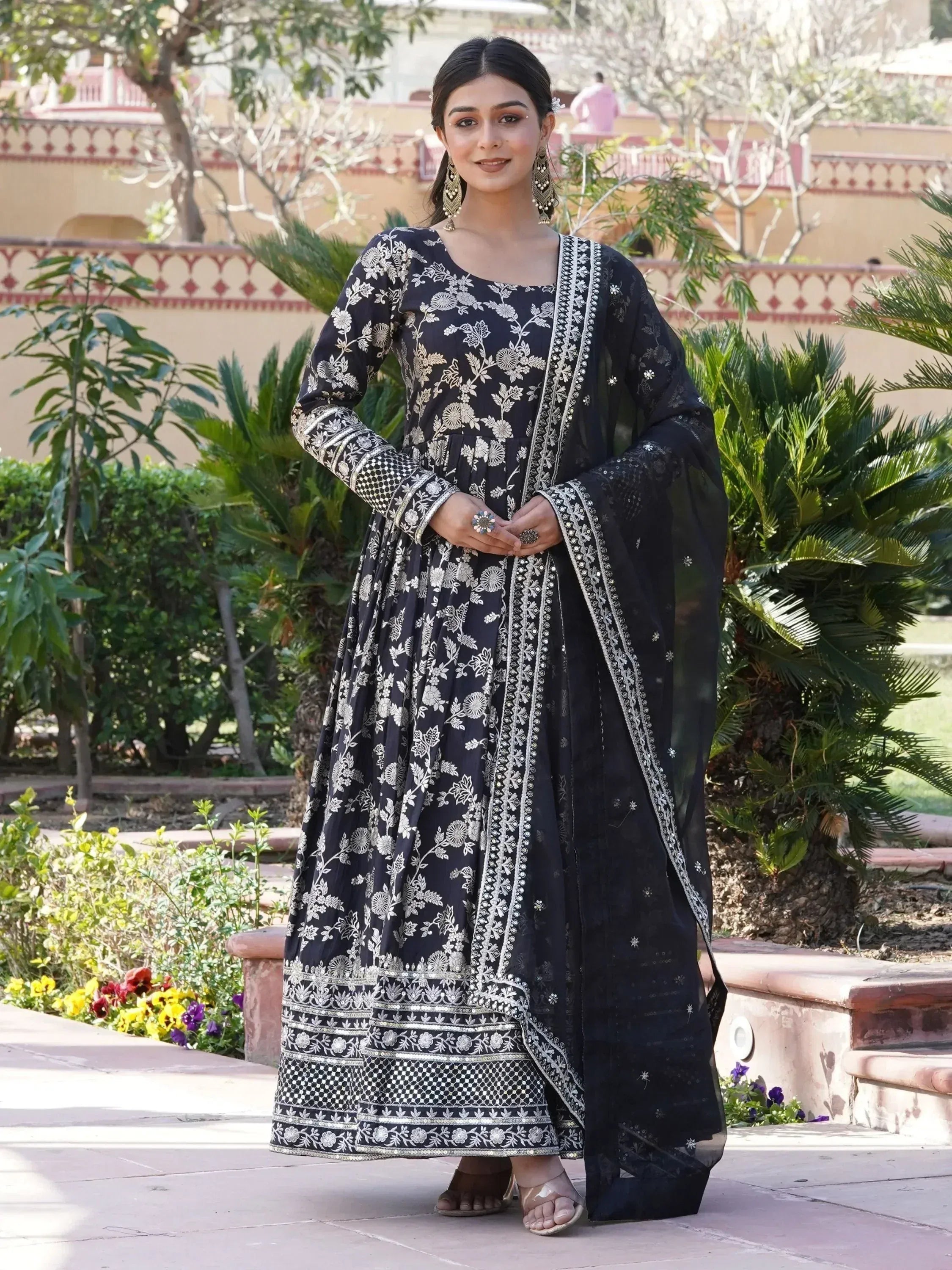 Woman in black and silver embroidered ethnic gown with dupatta, standing outdoors