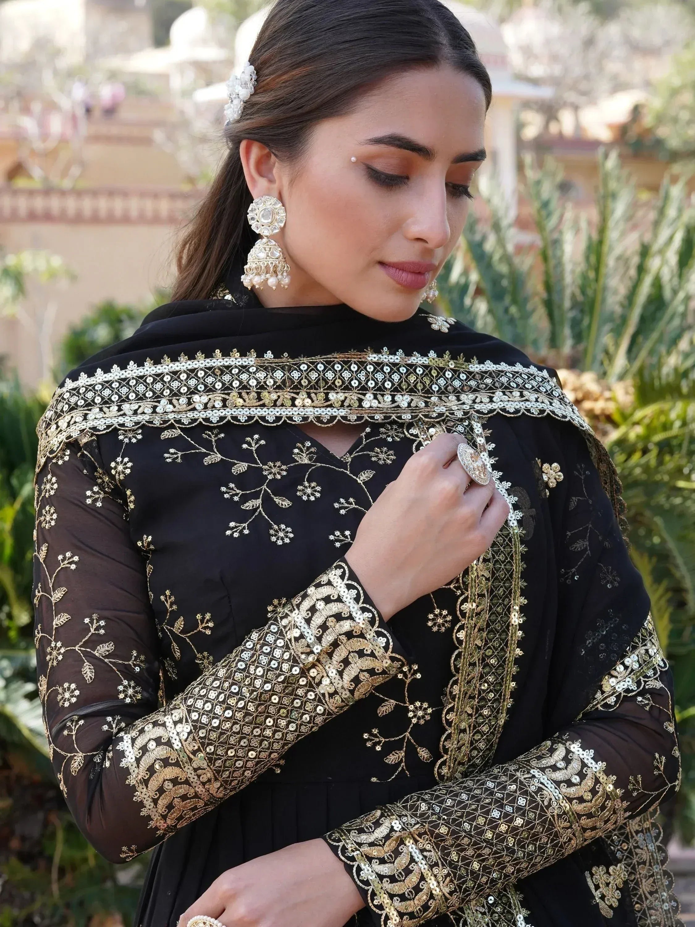 Black ethnic gown with gold embroidery and sequin detailing, perfect for Indian festive occasions.