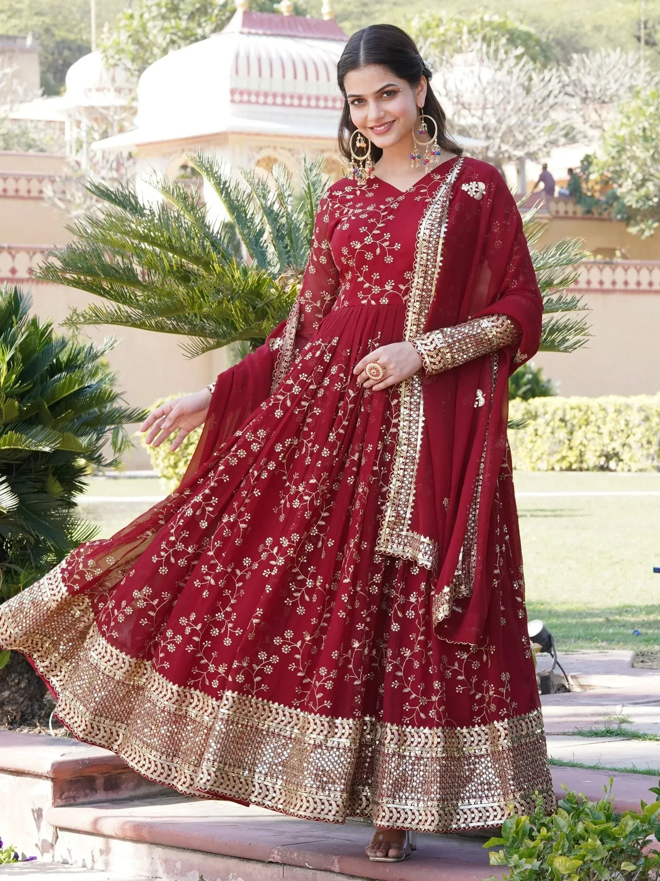 Maroon Indian ethnic gown with gold floral embroidery and mirror work, perfect for weddings and festive occasions.