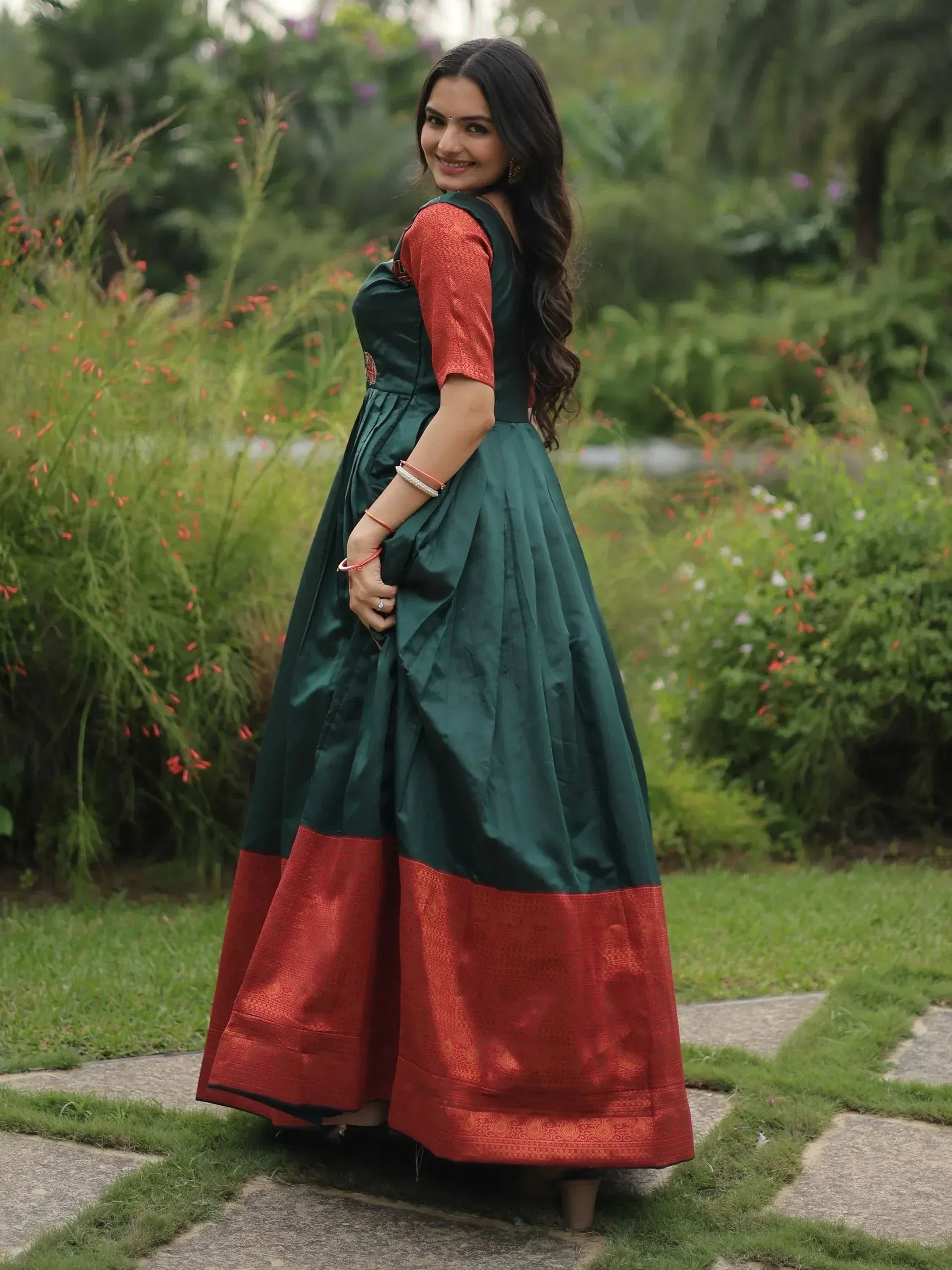 Elegant green and red ethnic gown with intricate detailing, perfect for festive occasions.