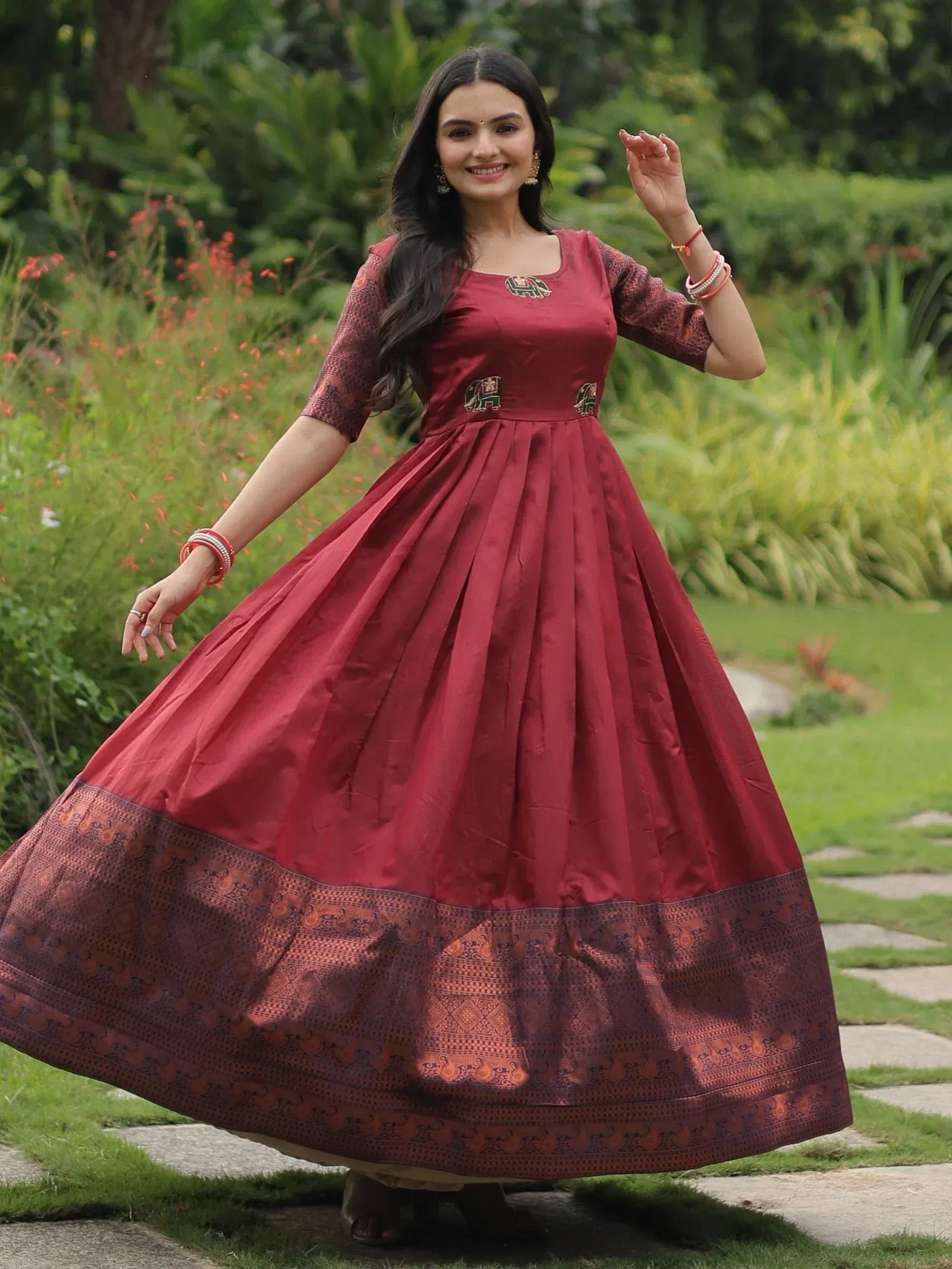 Woman in maroon ethnic gown with elephant embroidery, perfect for Indian occasions and festivals