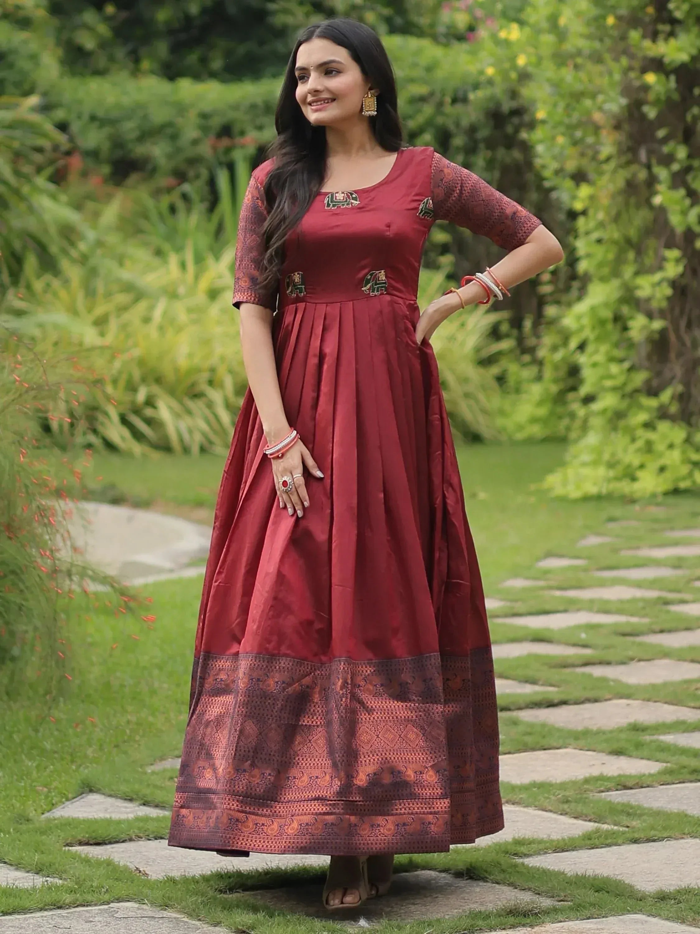Maroon ethnic gown with elephant embroidery and printed border, perfect for Indian occasions