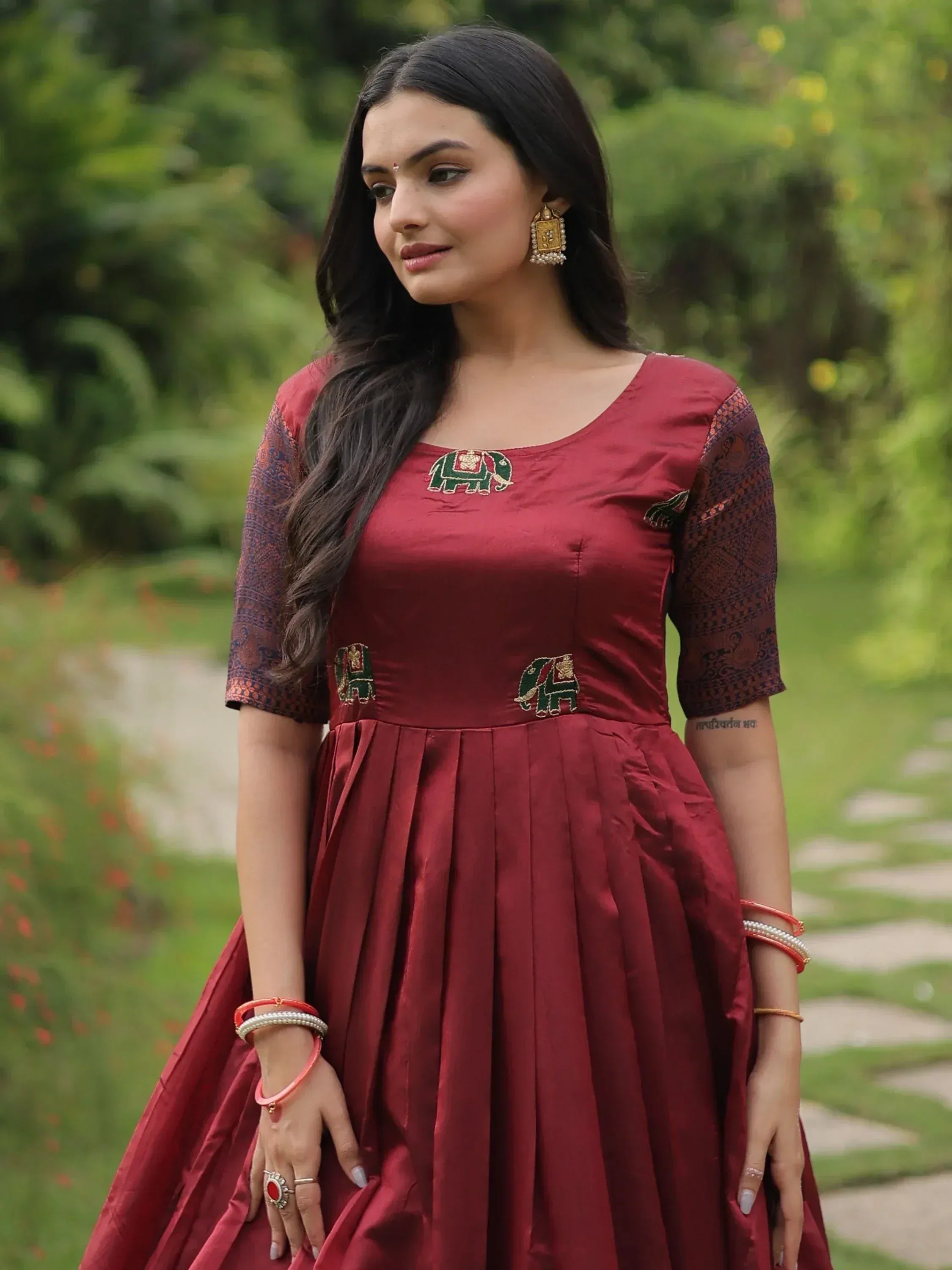 Maroon ethnic gown with elephant embroidery, perfect for Indian festive occasions and designer wear.