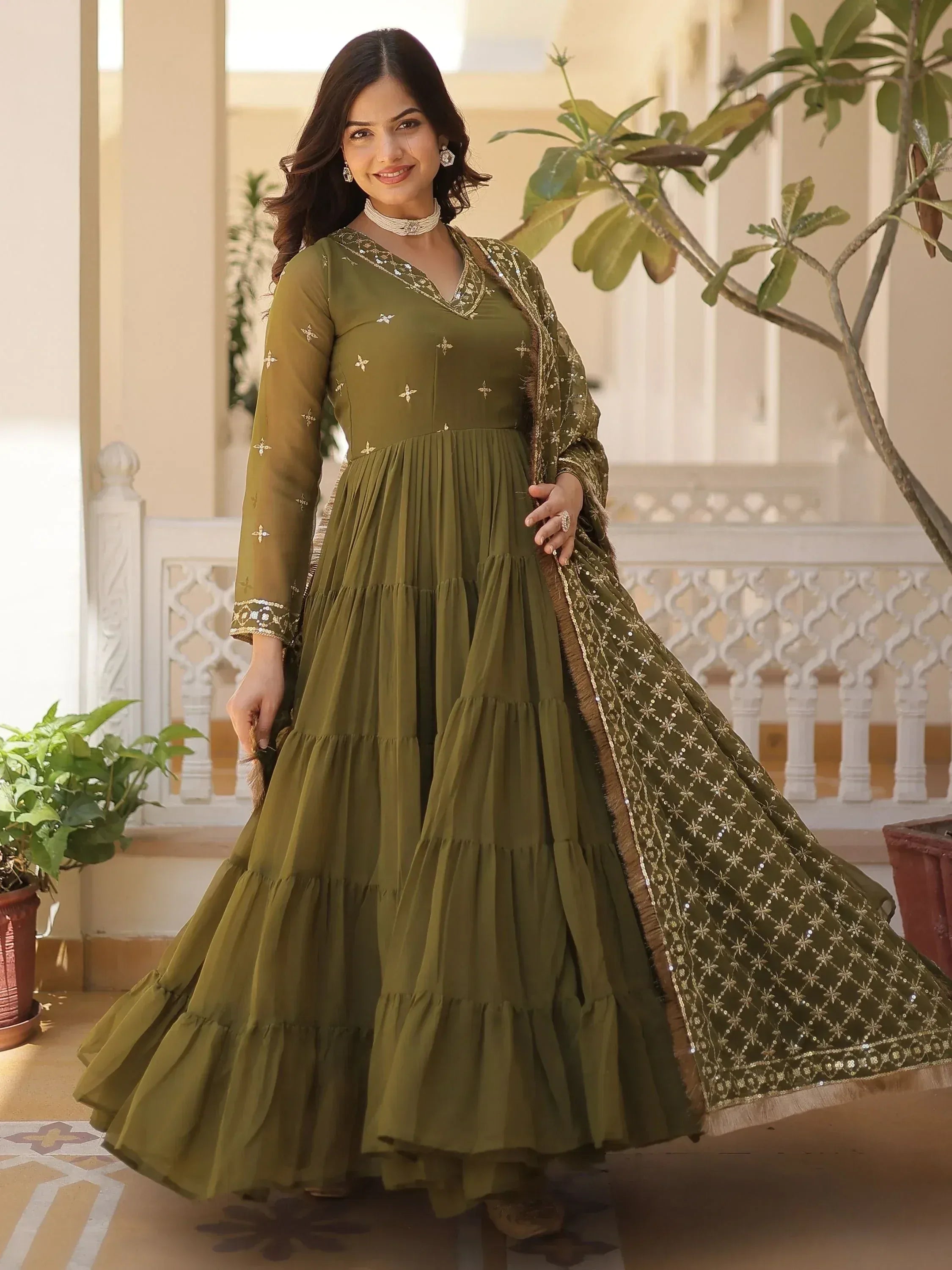 Olive green ethnic gown with gold embroidery and tiered skirt, perfect for Indian festive occasions.