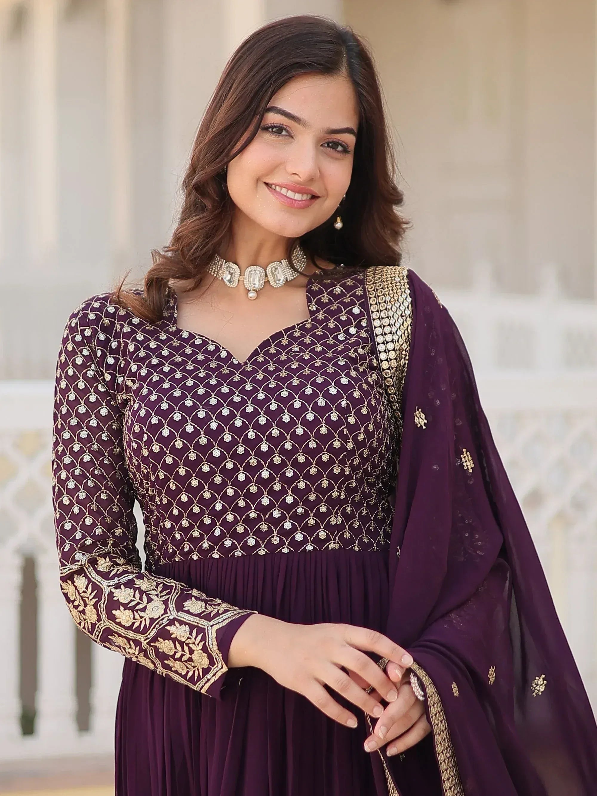 Elegant purple ethnic gown with gold embroidery, perfect for Indian occasions and festive wear.