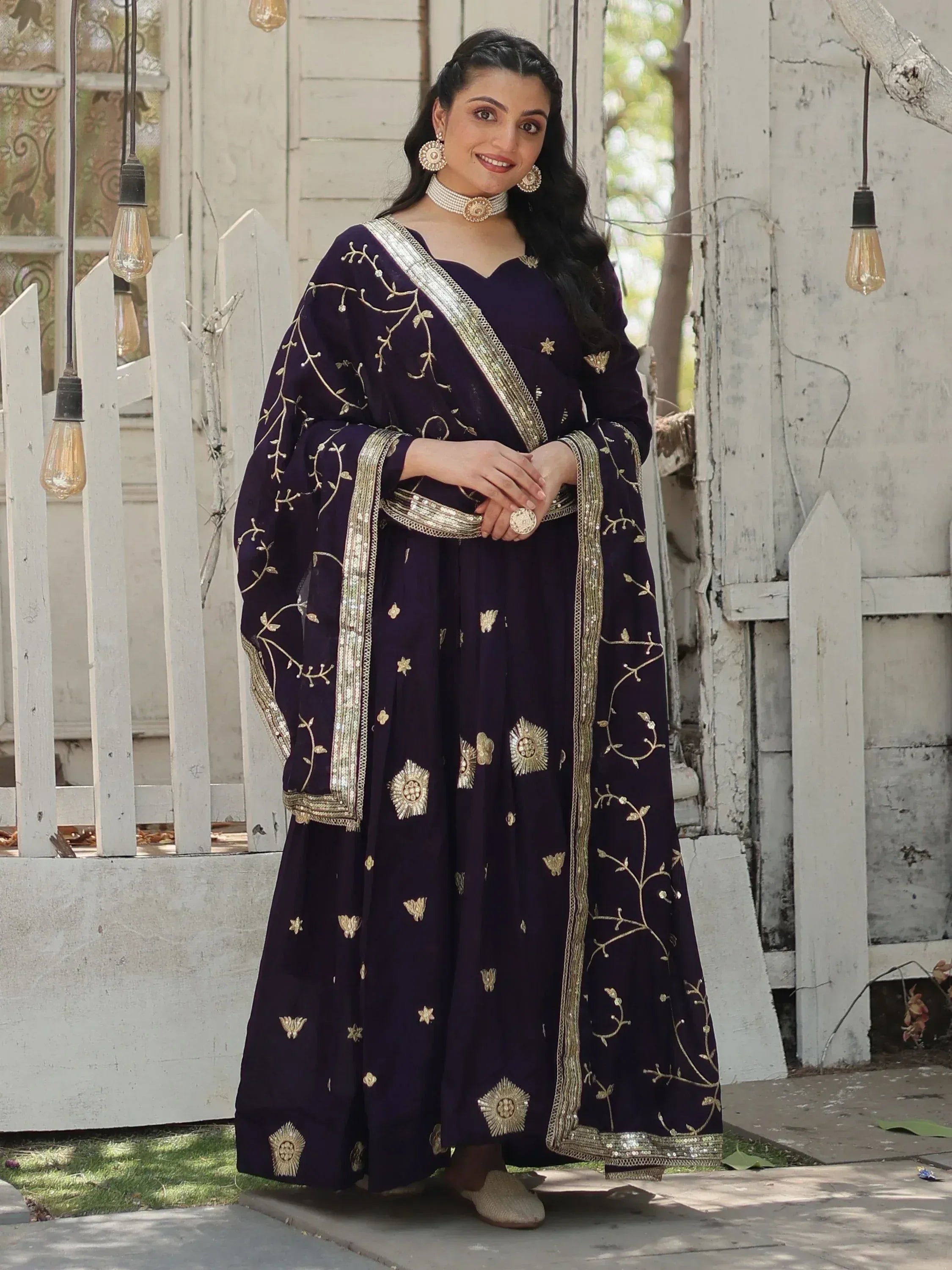 Elegant purple Indian ethnic gown with gold embroidery, perfect for festive occasions and weddings.