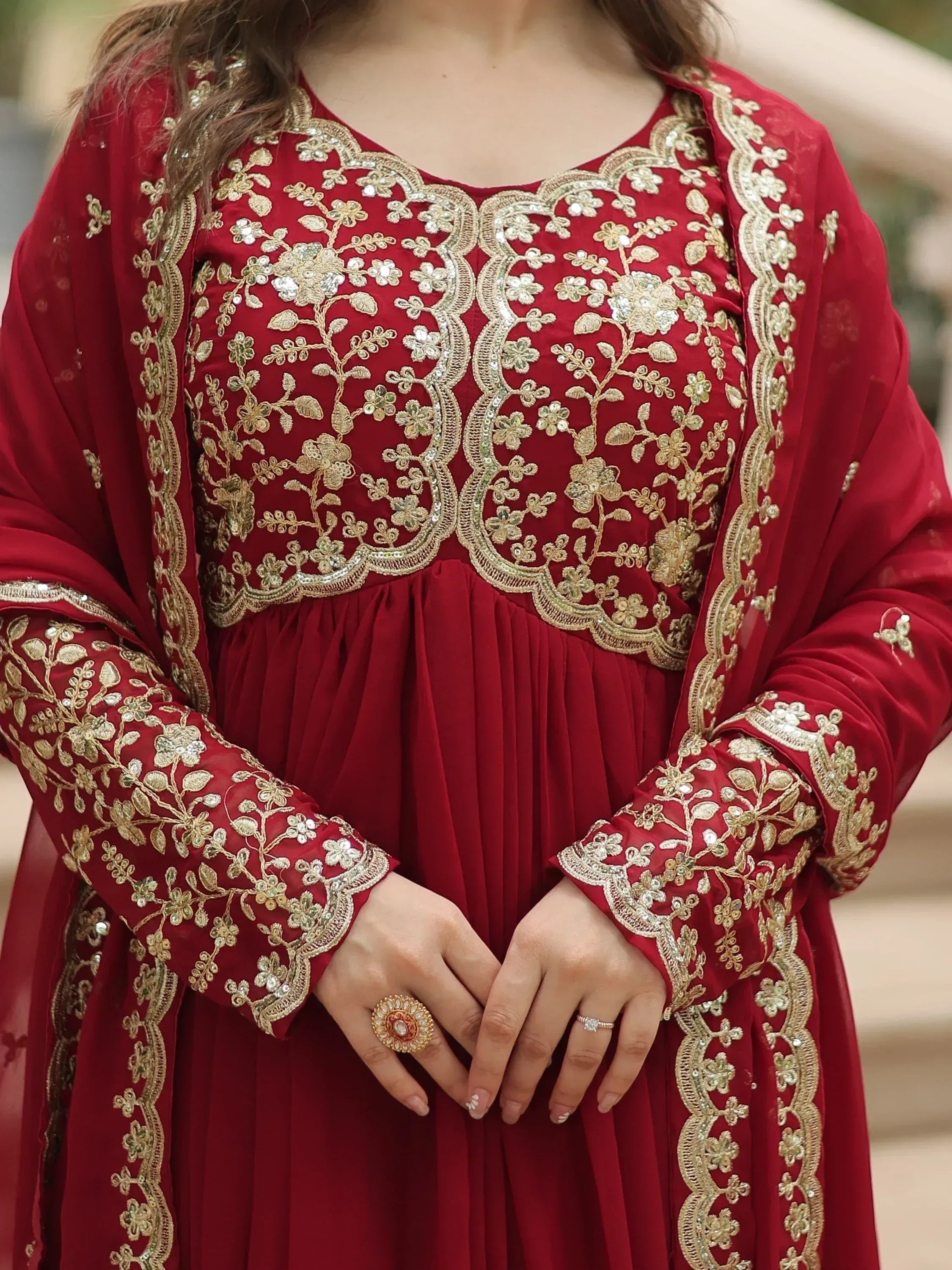 Red ethnic gown with gold floral embroidery and sequins, perfect for Indian weddings or festive occasions.