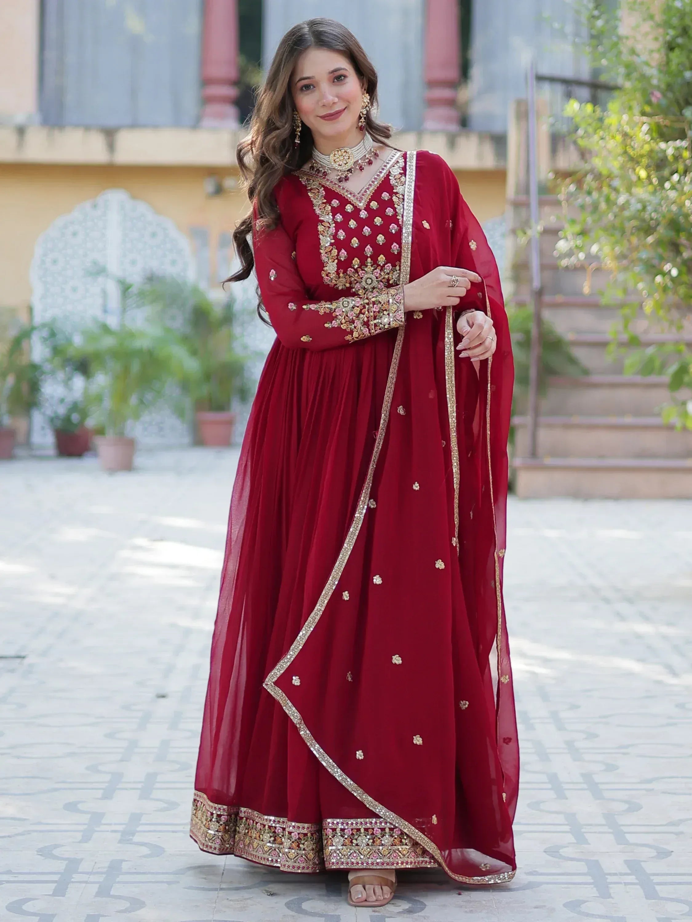 Elegant maroon Indian ethnic gown with gold embroidery, perfect for weddings and festive occasions.