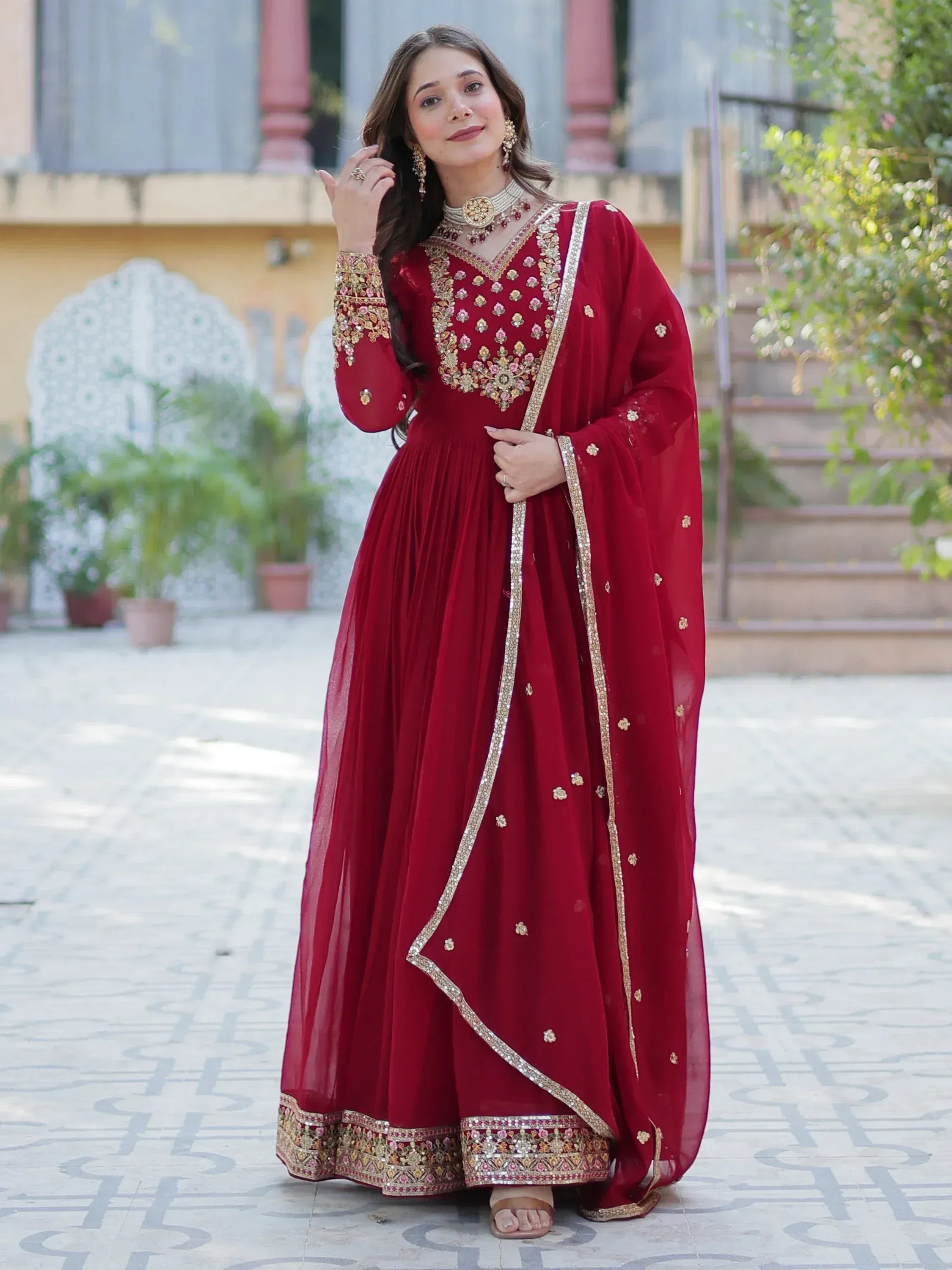 Elegant maroon ethnic gown with gold embroidery, perfect for Indian weddings and festive occasions.