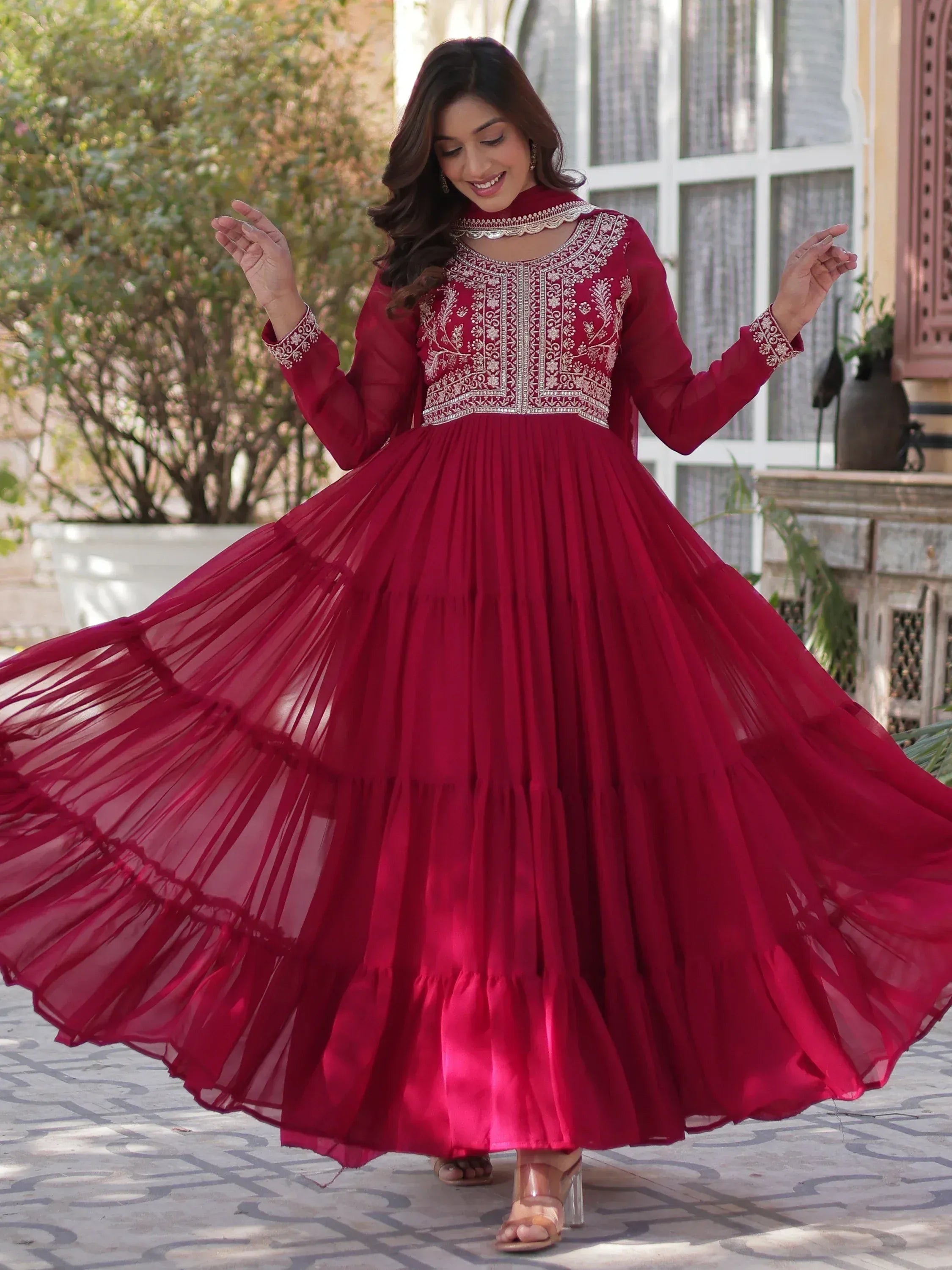 Elegant maroon ethnic gown with intricate embroidery and flowing skirt for festive occasions
