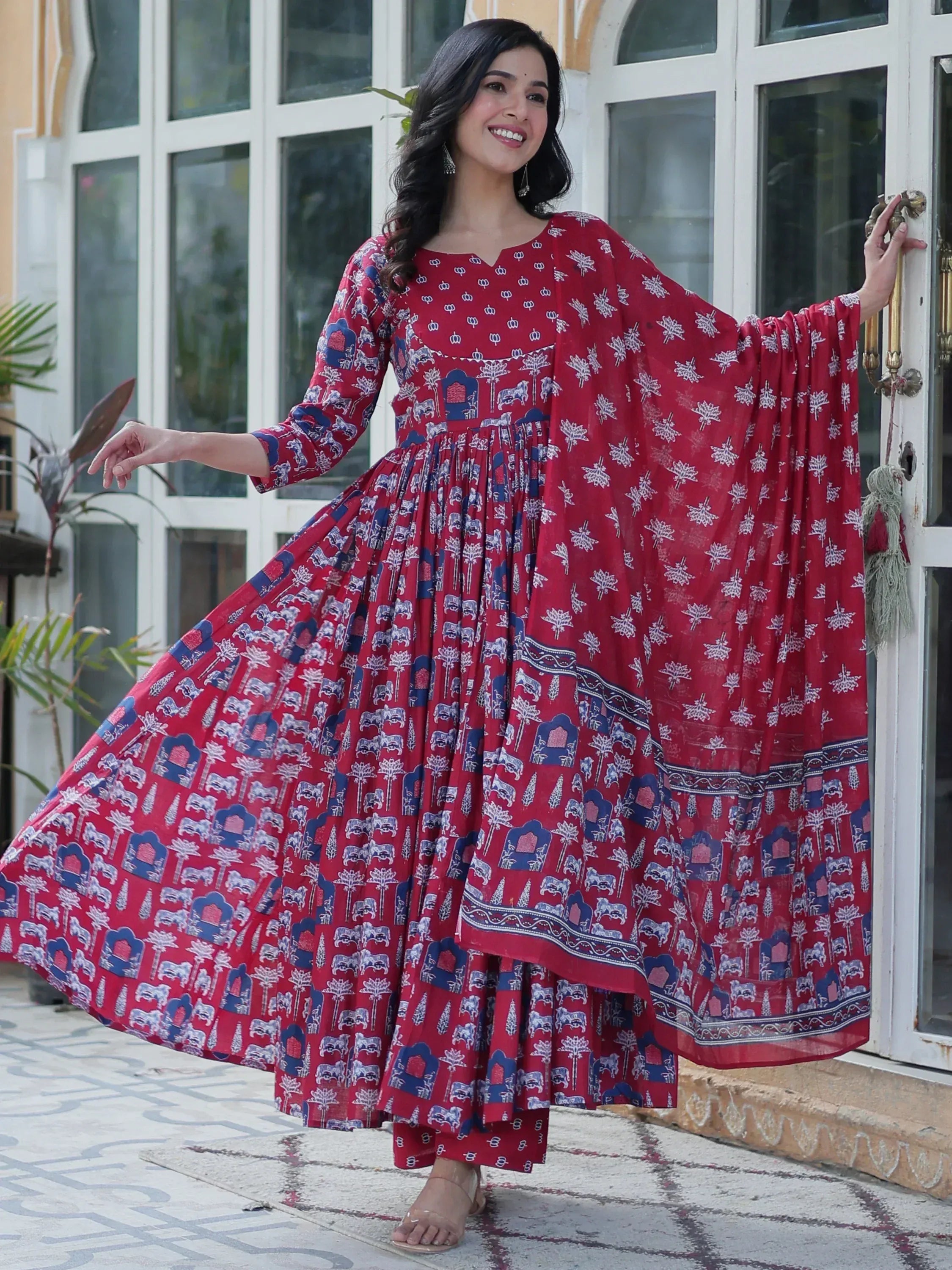 Red printed ethnic gown with elephant motifs, flared skirt, and cape sleeves for women