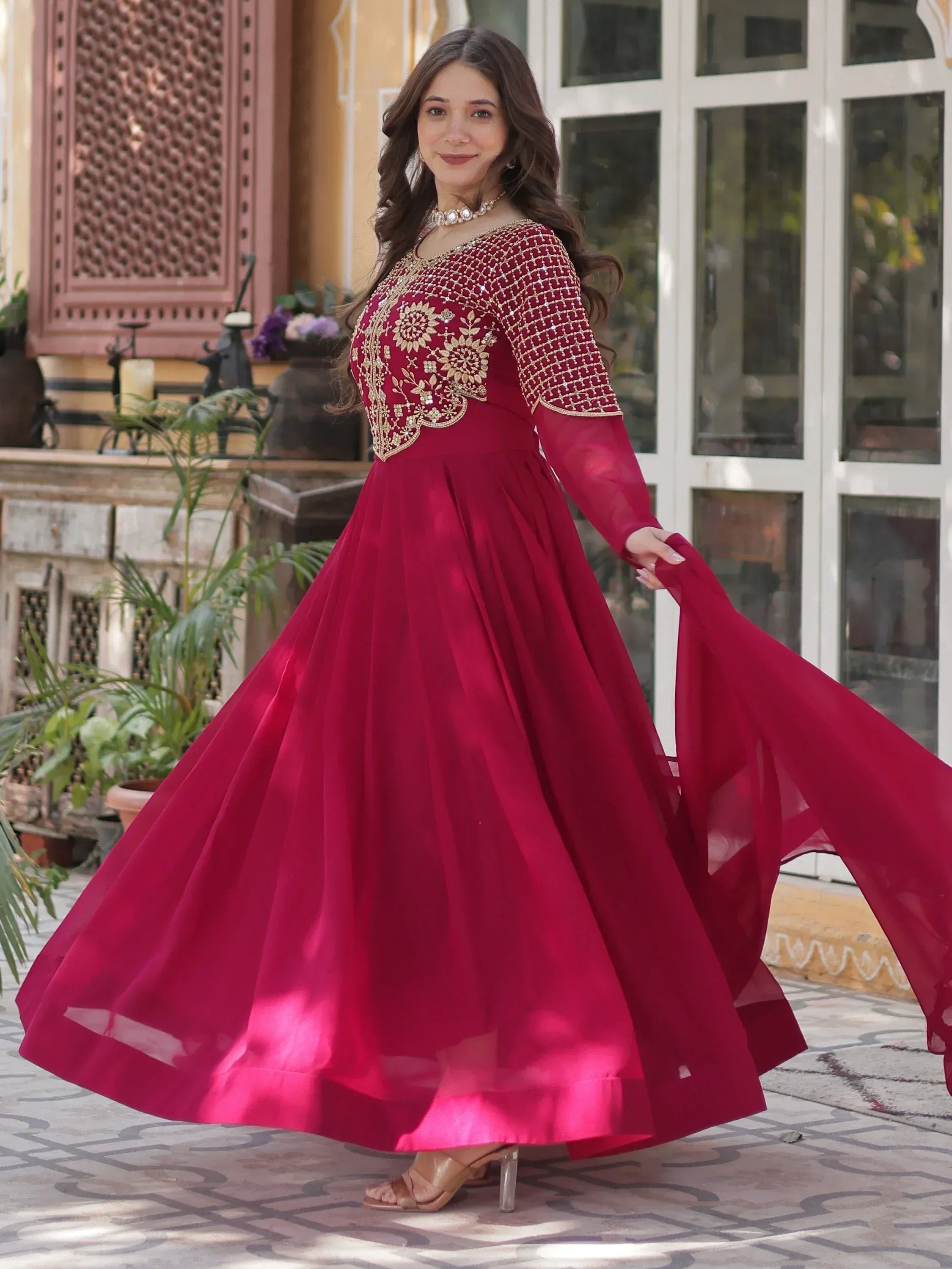 Elegant maroon ethnic gown with gold embroidery, perfect for Indian celebrations and events.
