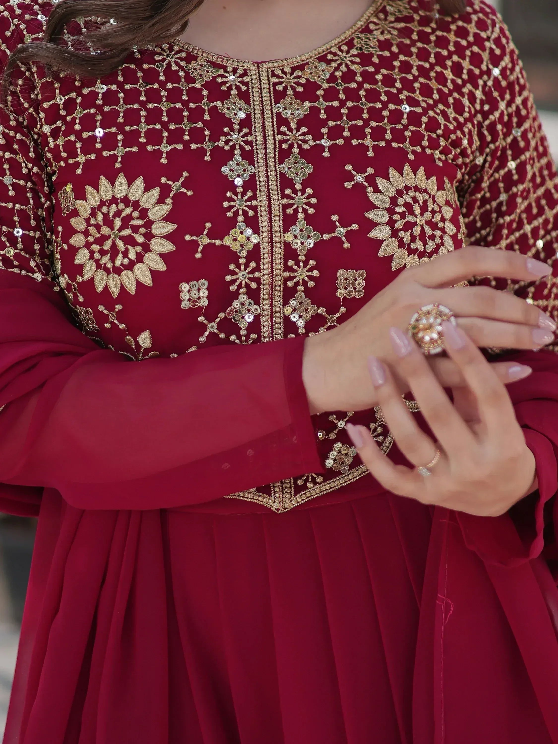 Maroon ethnic gown with gold embroidery and sequins, perfect for Indian weddings or festive occasions.