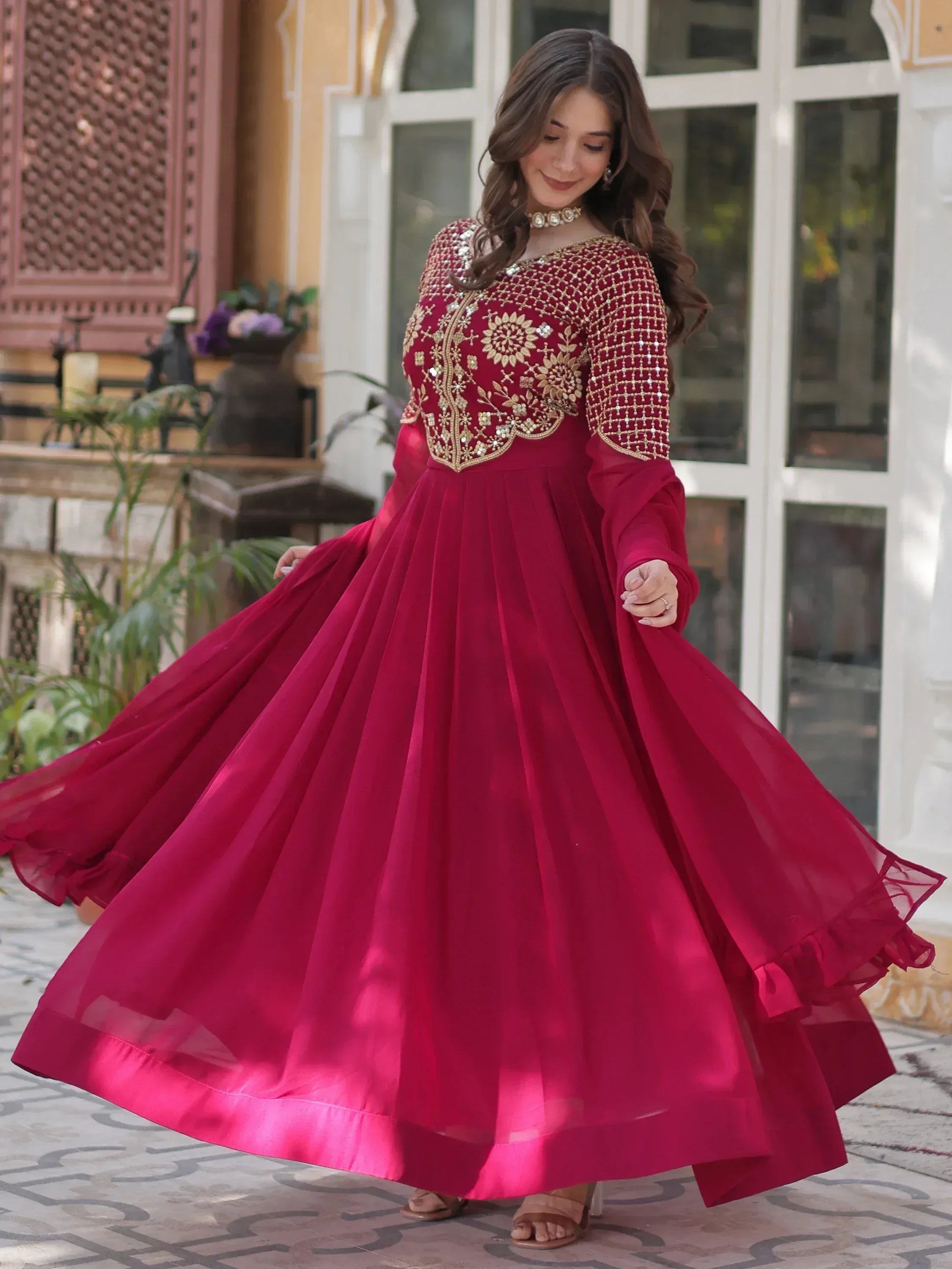 Elegant maroon ethnic gown with gold embroidery, perfect for Indian celebrations and festive occasions.