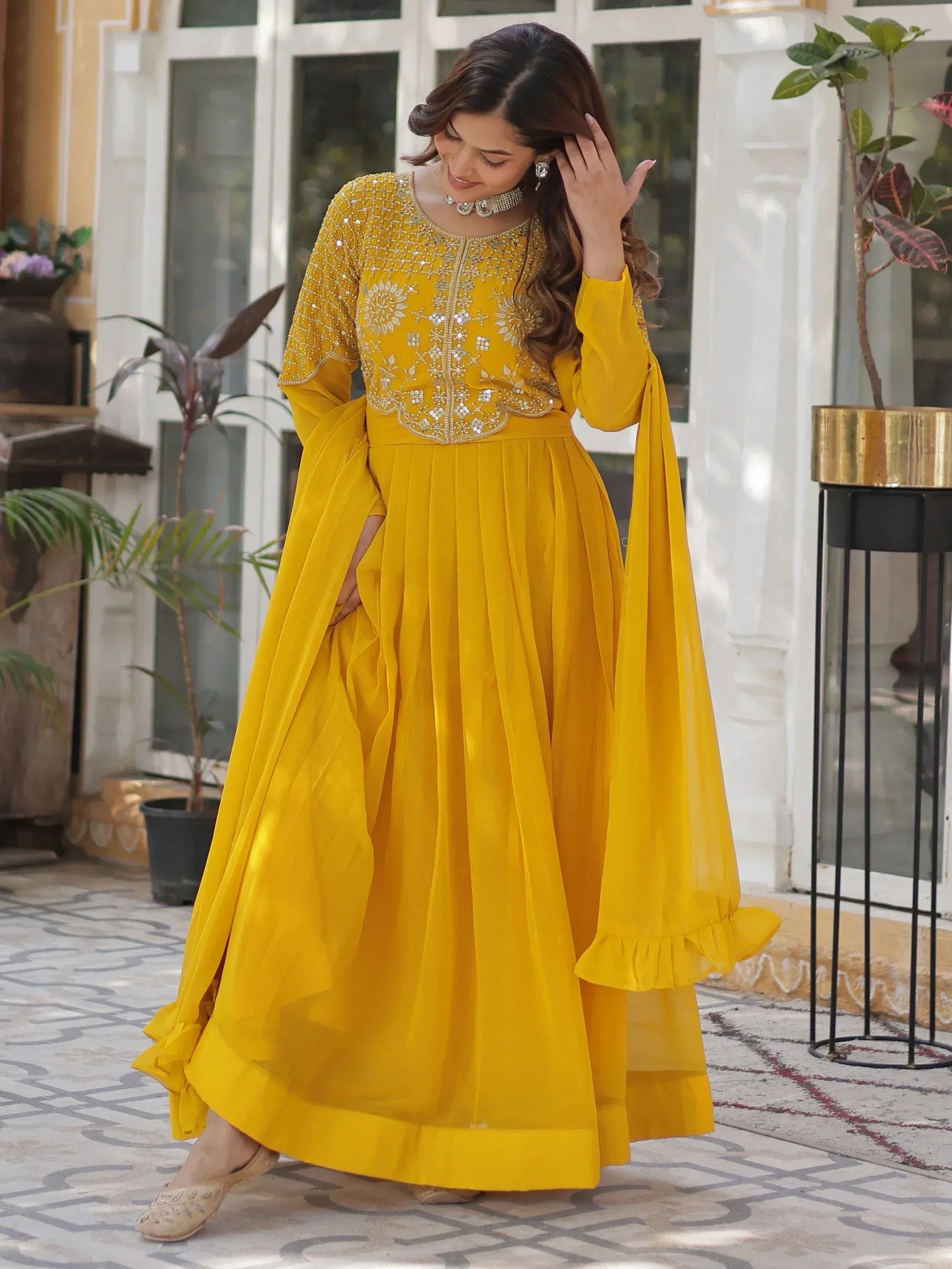 Yellow embroidered ethnic gown with flared skirt and ruffled sleeves for festive occasions