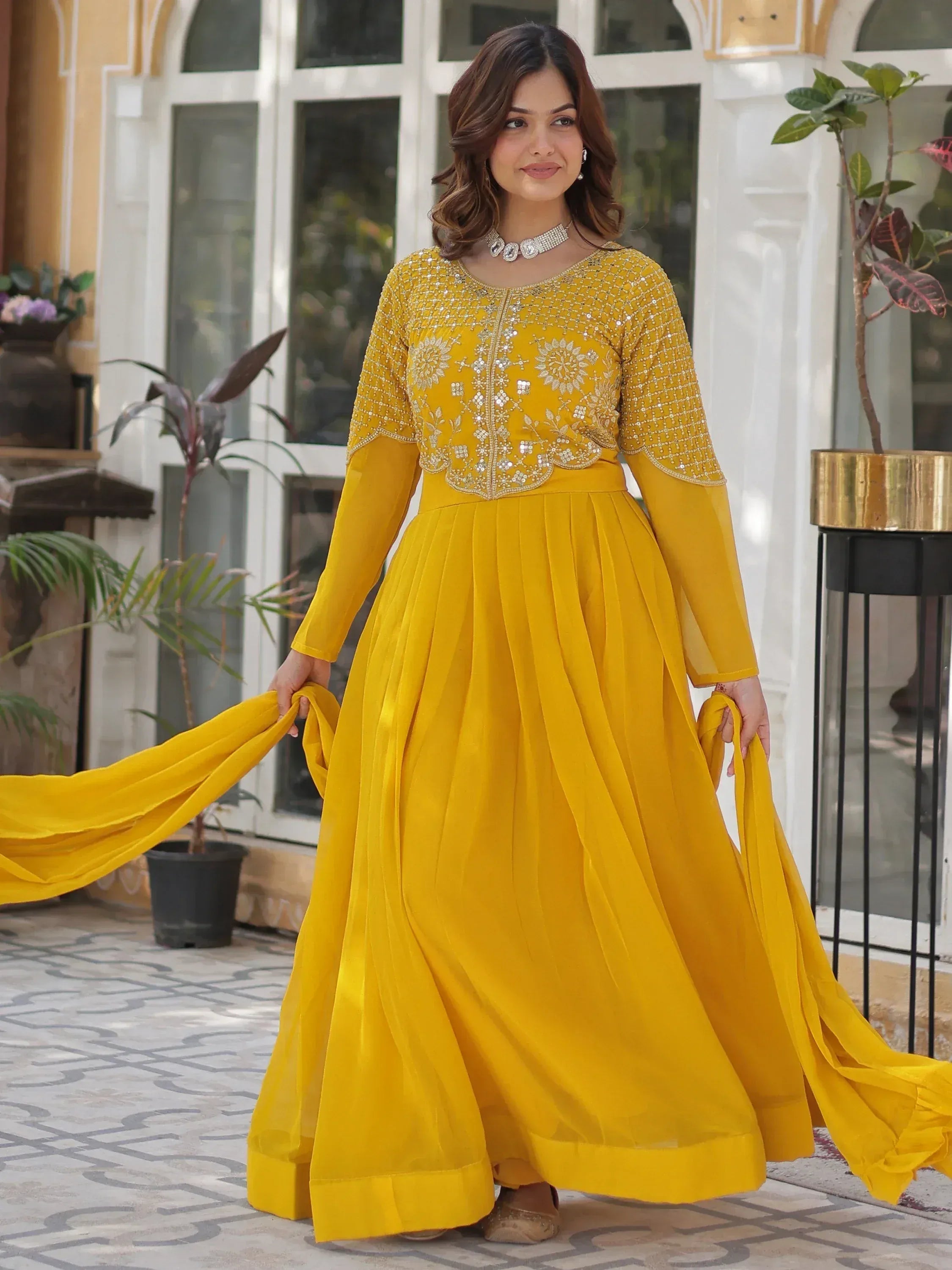 Yellow embroidered ethnic gown with flared skirt and dupatta, perfect for Indian festive occasions