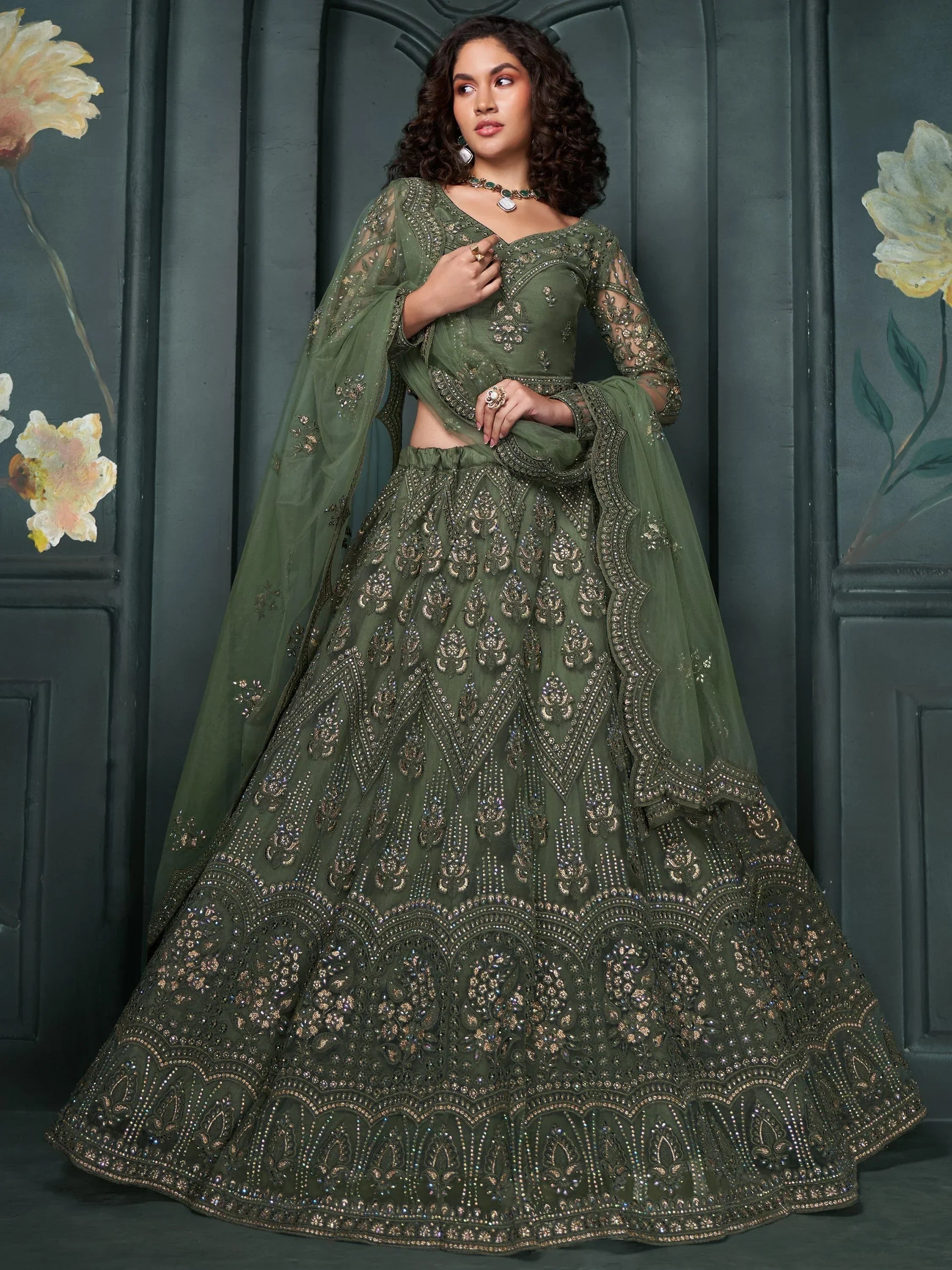 Olive green designer lehenga choli with heavy embroidery and sheer dupatta, perfect for Indian ethnic occasions.