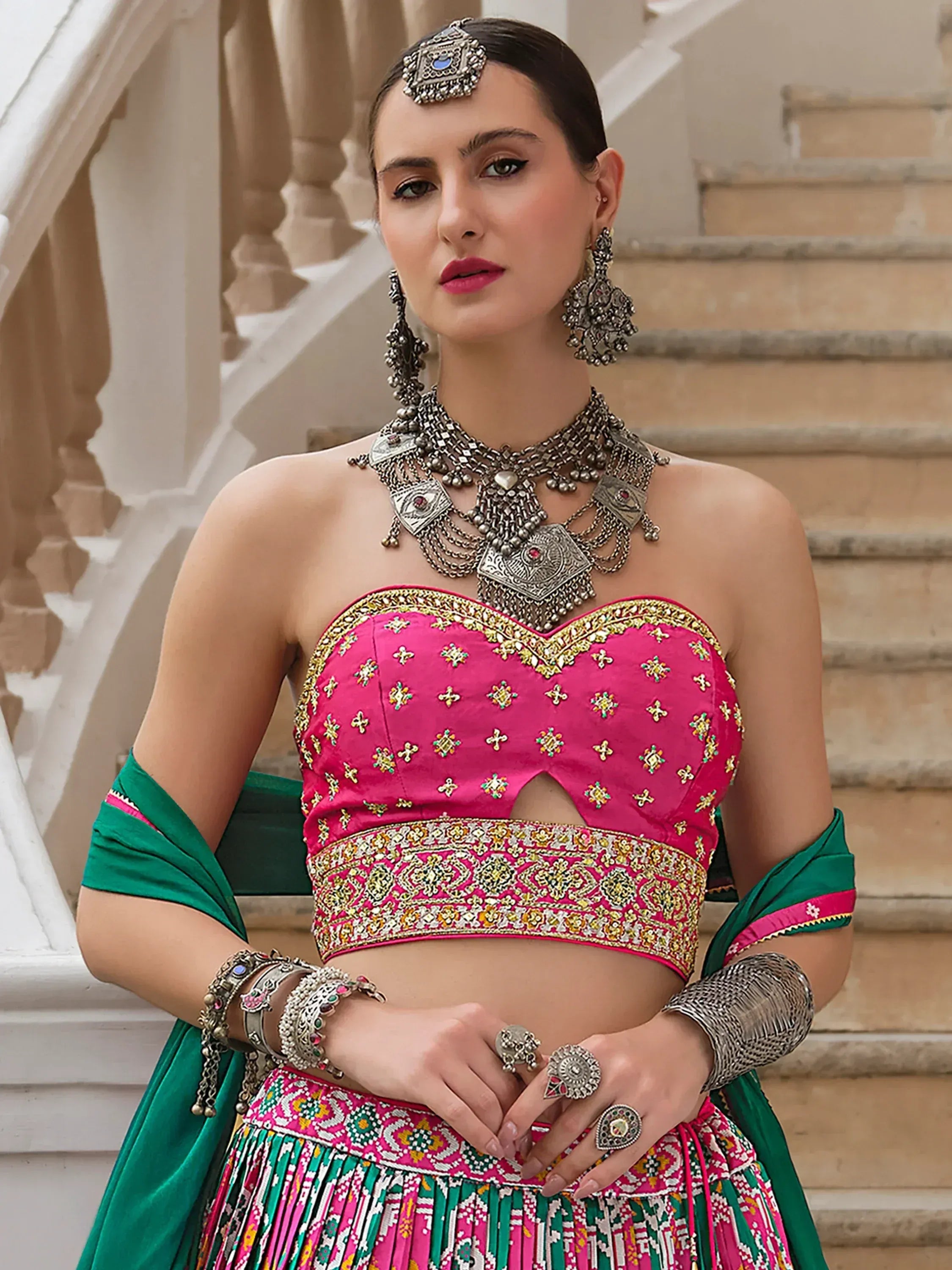 Pink and green embroidered lehenga choli with traditional jewelry, perfect for Indian ethnic wear