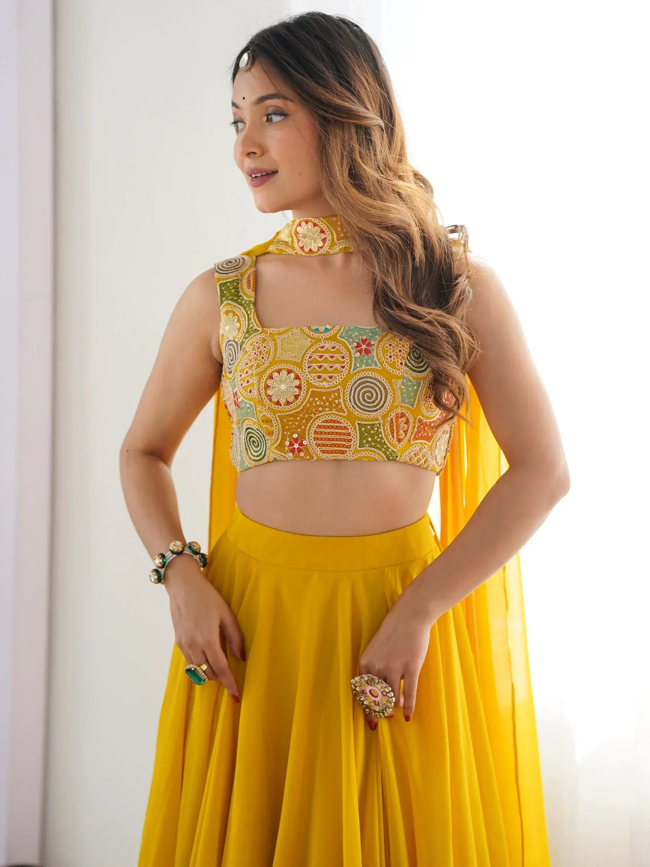 Yellow embroidered lehenga choli with floral patterns, perfect for Indian ethnic wear events
