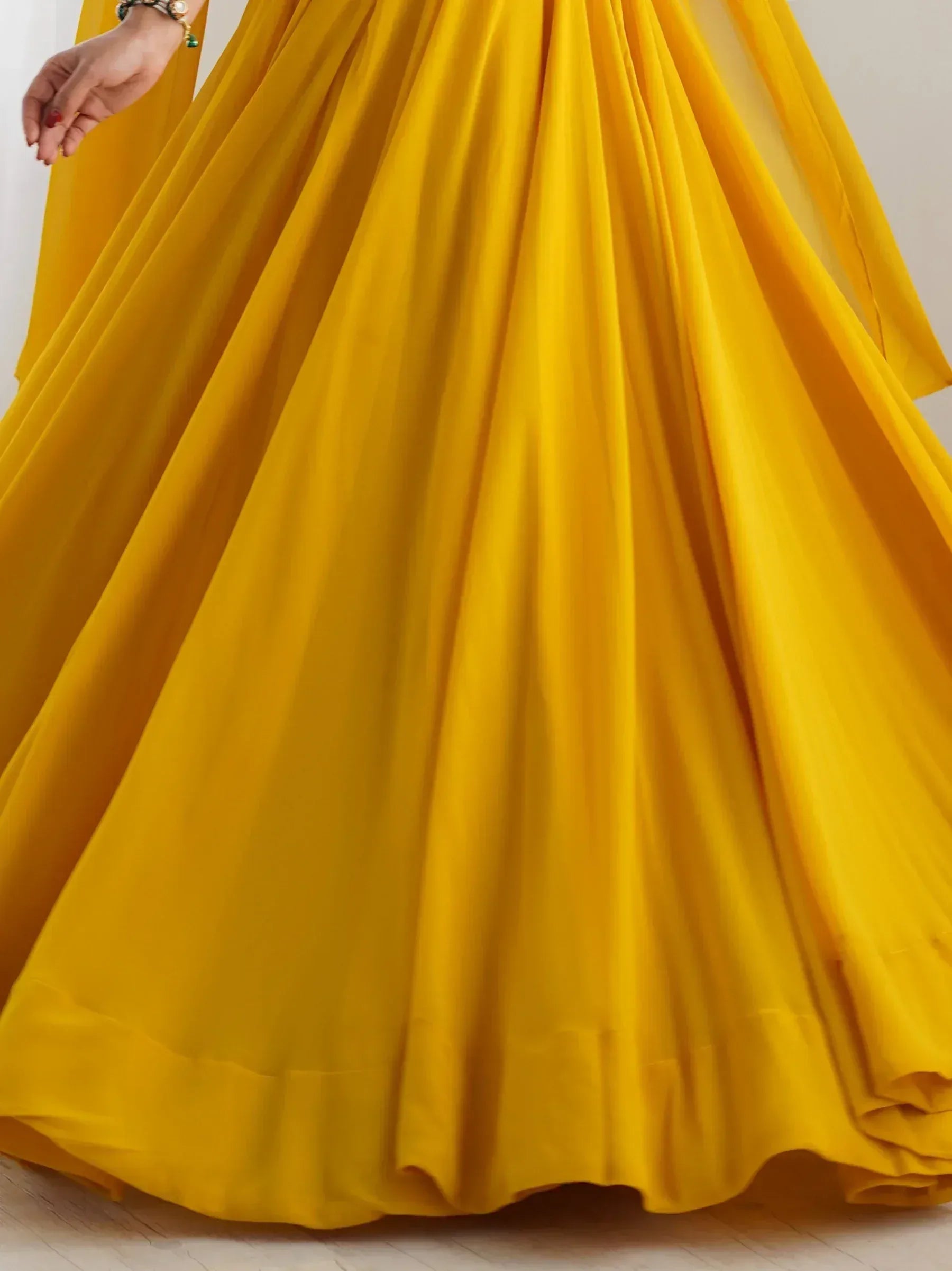 Vibrant yellow ethnic gown with flowing pleats, perfect for Indian festive occasions