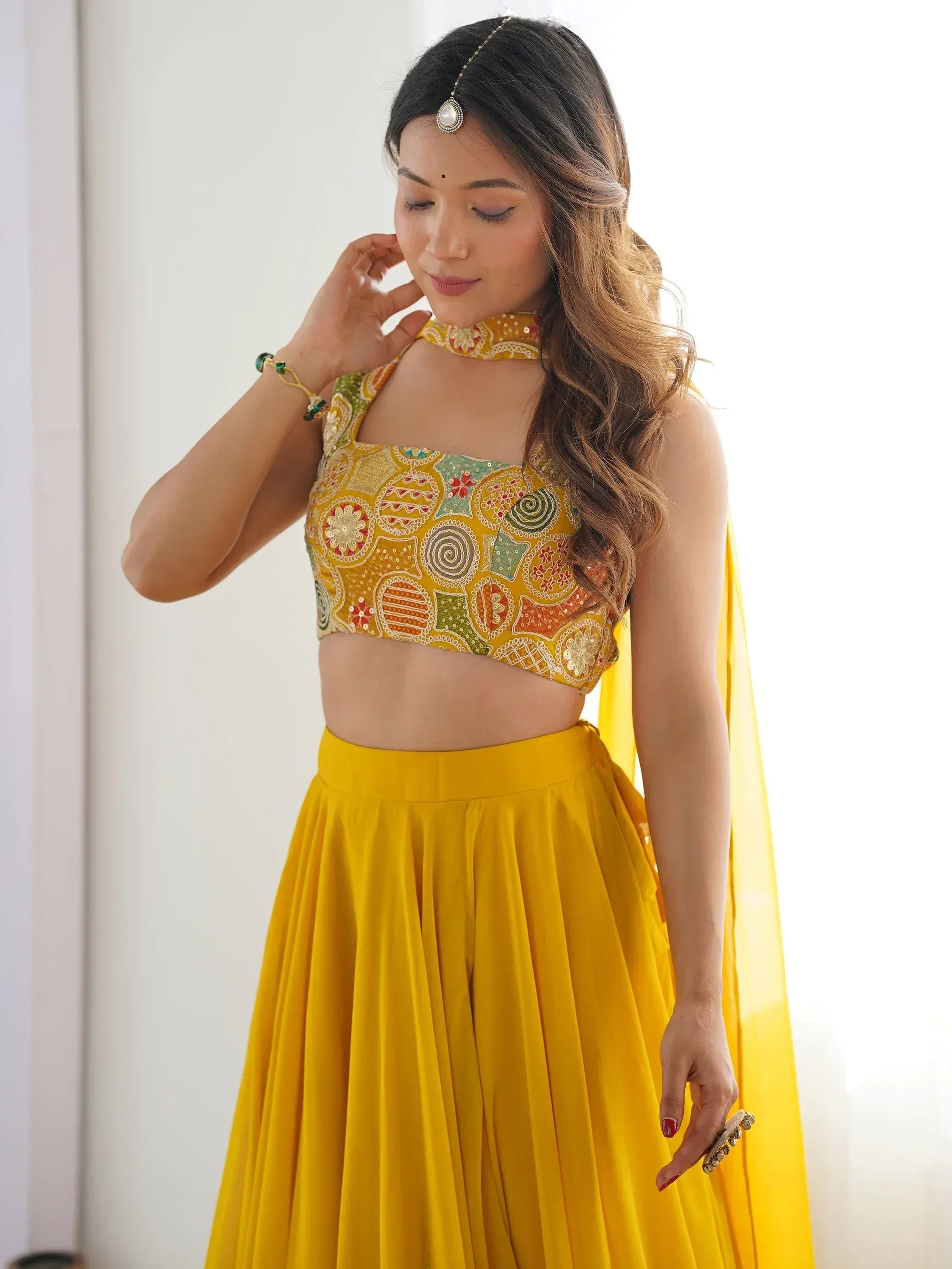 Yellow embroidered lehenga choli with floral motifs, perfect for Indian ethnic wear and festive occasions.