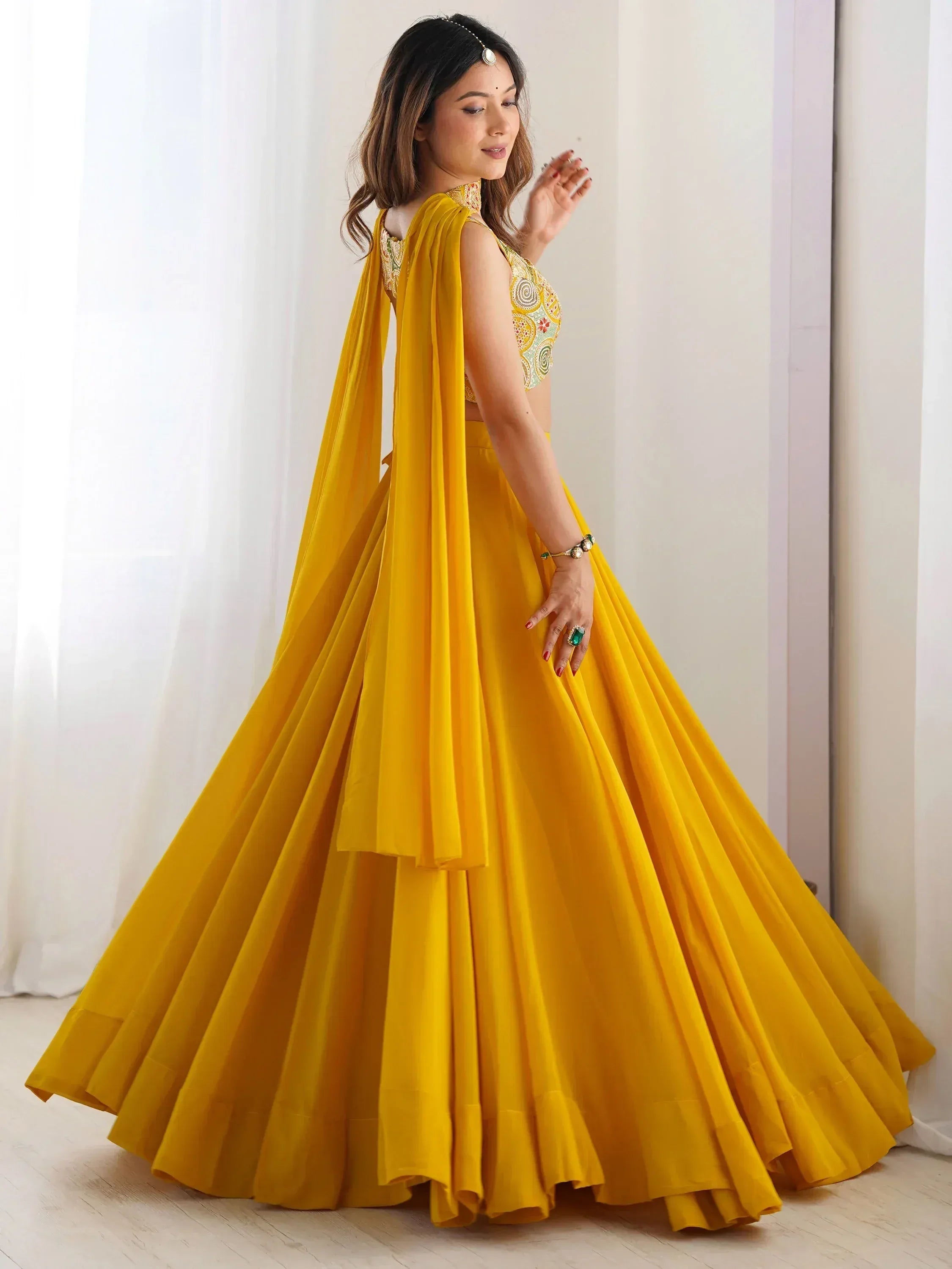 Yellow designer lehenga choli with embroidered blouse and flowing skirt, perfect for Indian ethnic occasions