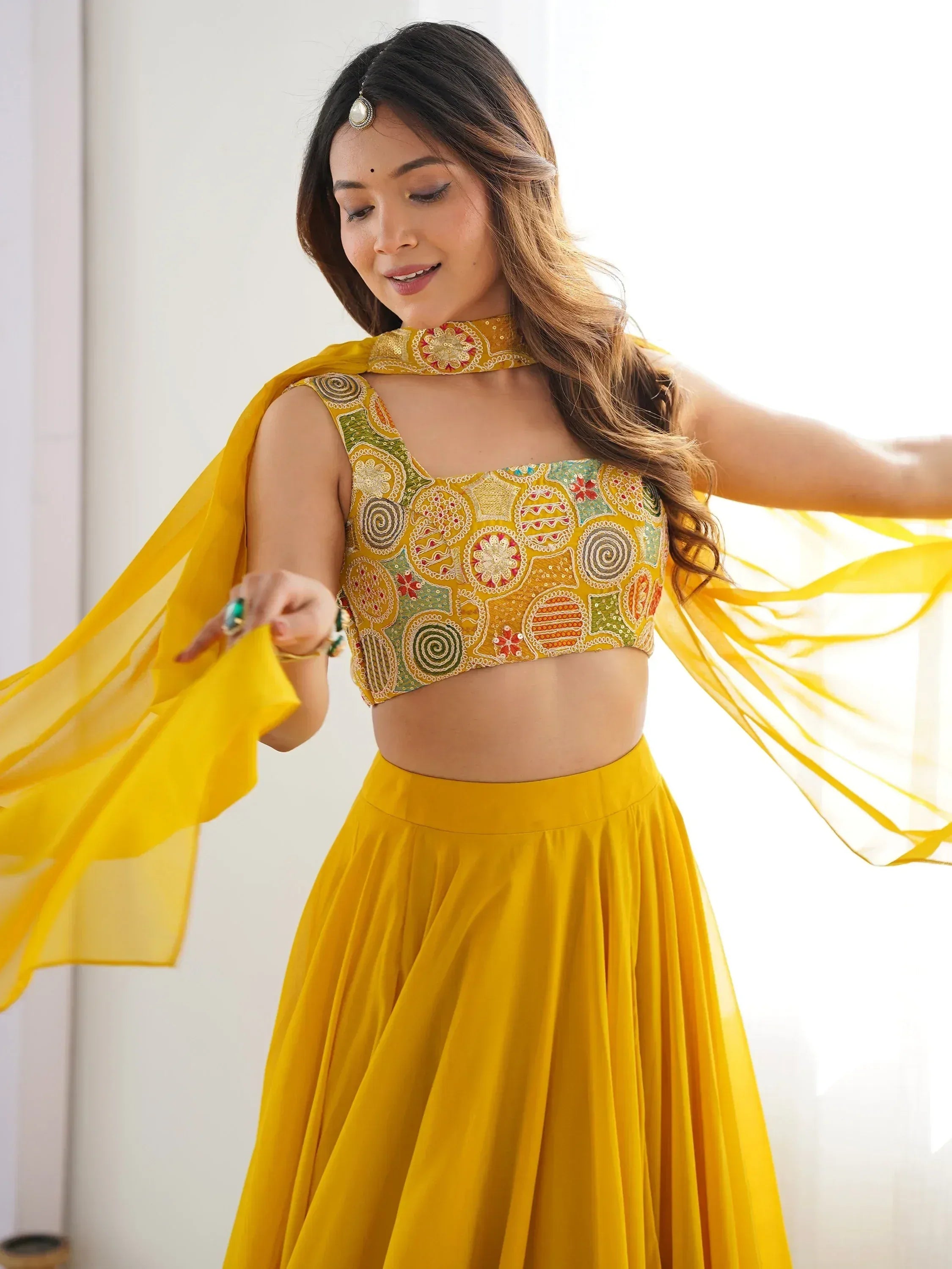 Yellow embroidered lehenga choli with floral motifs and matching dupatta, ideal for Indian ethnic wear occasions.