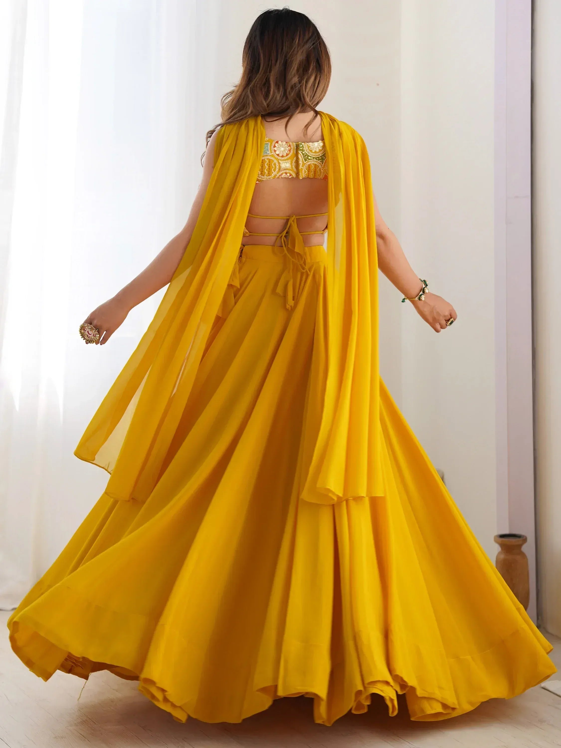 Yellow designer lehenga choli with embroidered blouse and flowing skirt, perfect for Indian ethnic wear