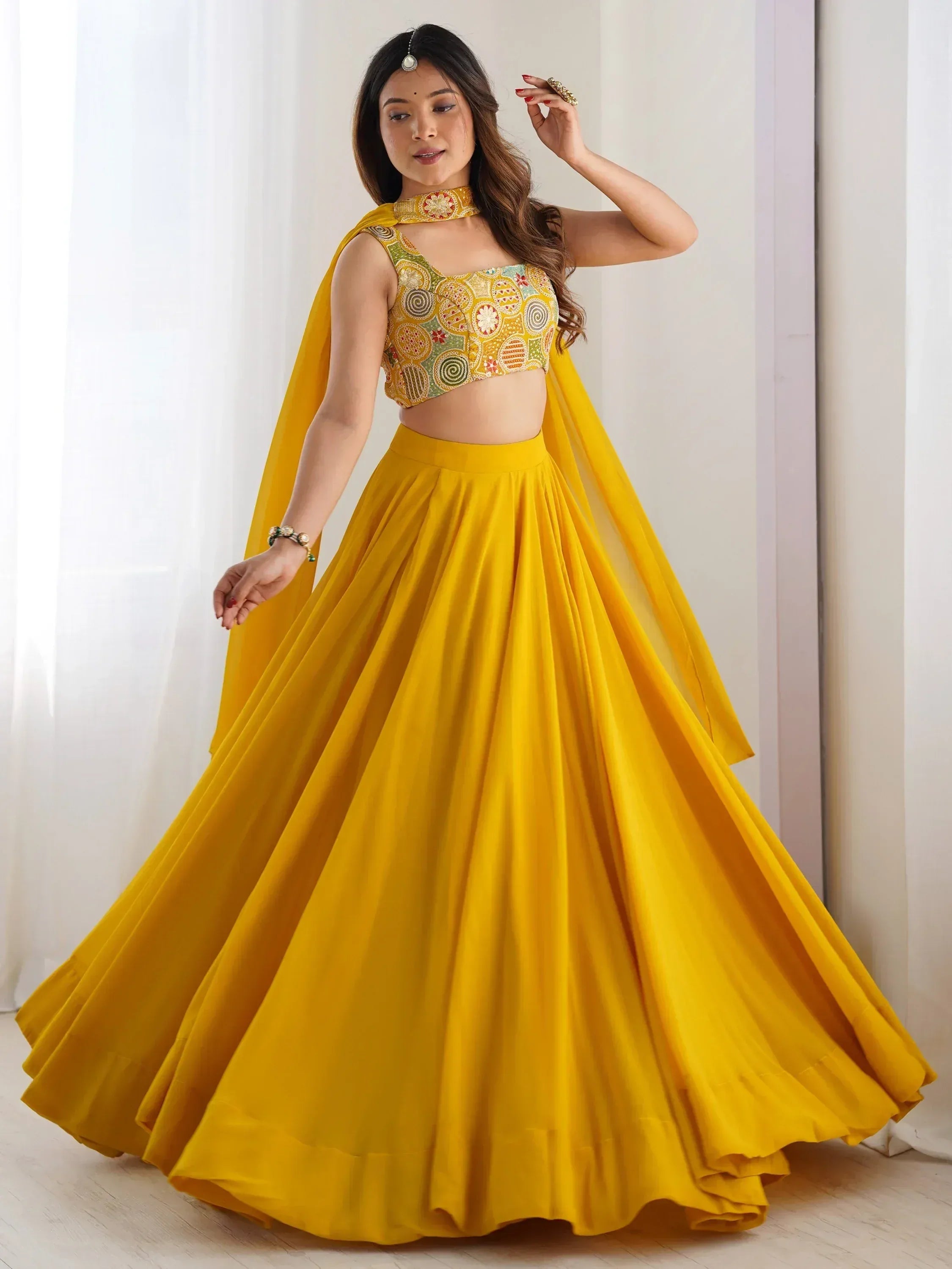 Yellow designer lehenga choli with embroidered blouse and flowing skirt, perfect for Indian ethnic occasions