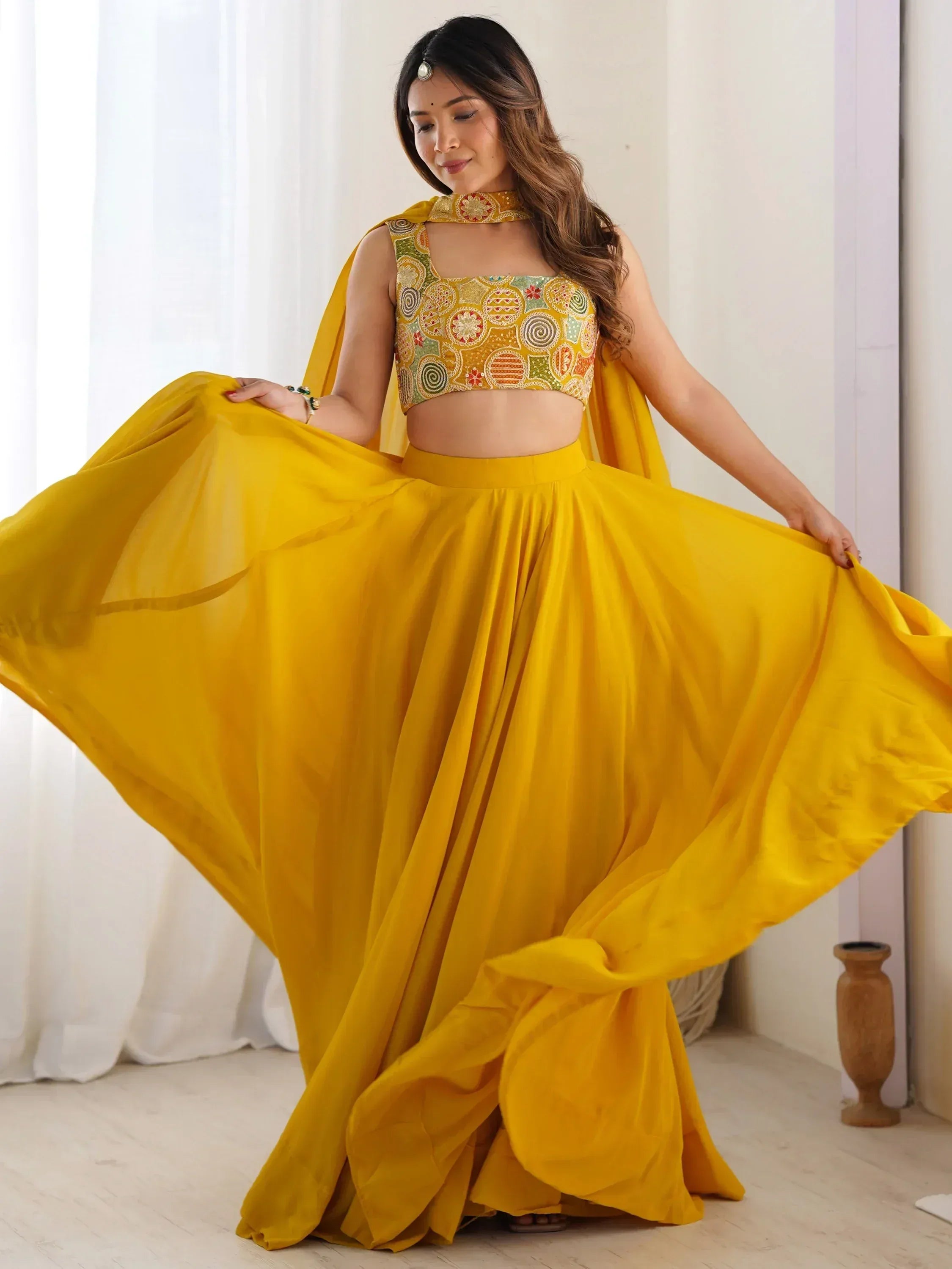 Yellow designer lehenga choli with embroidered blouse and flowing skirt, perfect for Indian ethnic wear occasions