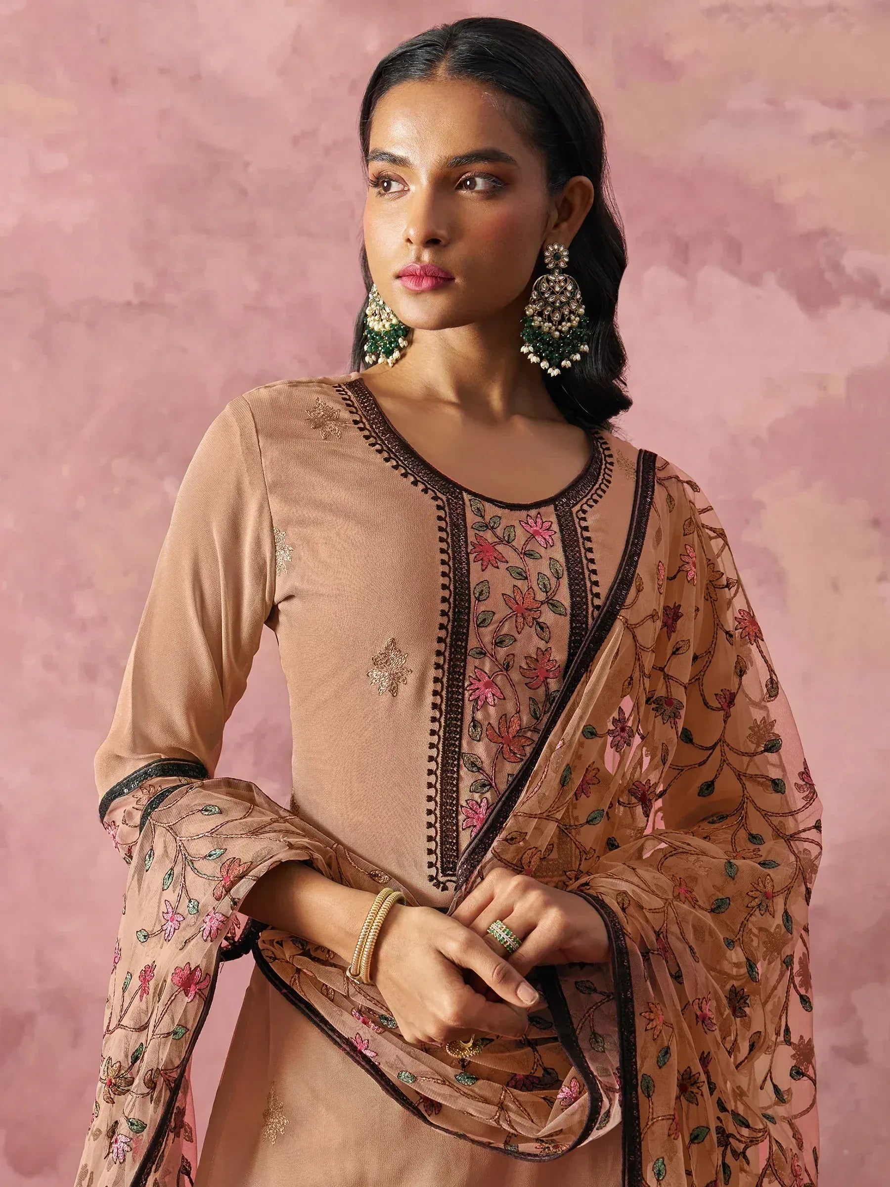 Elegant beige salwar kameez with floral embroidery and sheer dupatta, paired with statement earrings.