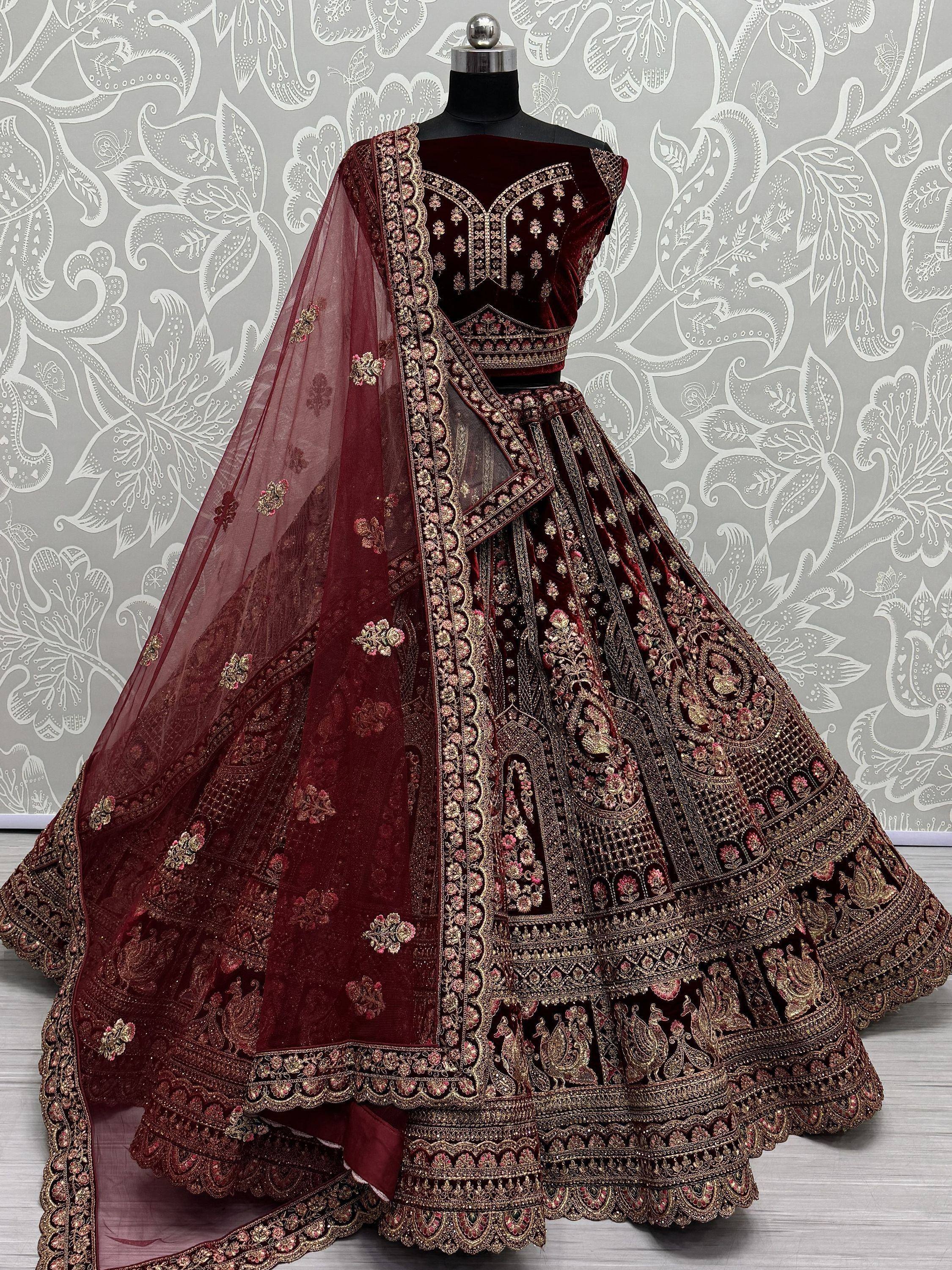 Maroon velvet designer lehenga choli with heavy gold embroidery and sheer dupatta, perfect for weddings