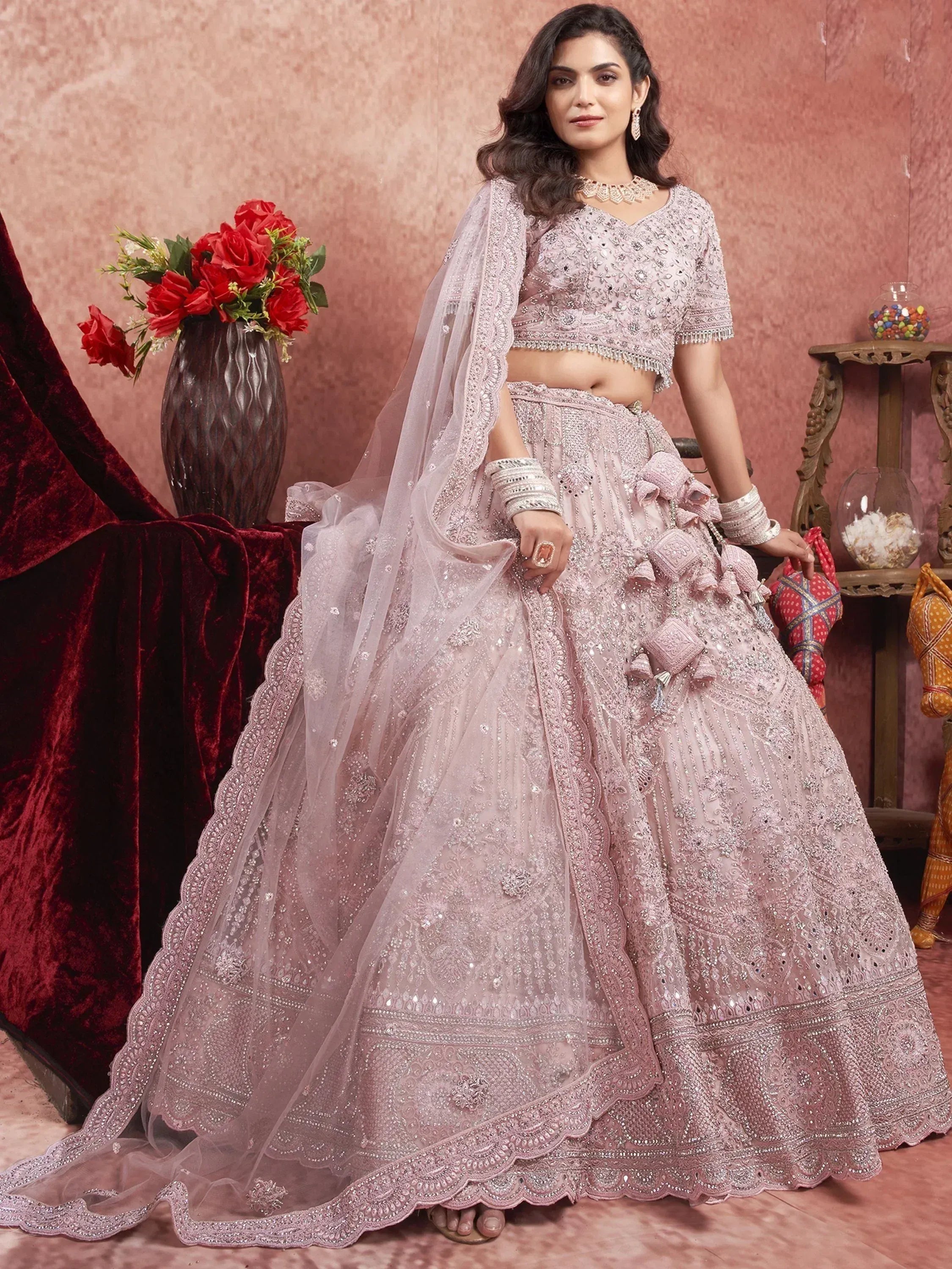 Elegant pink designer lehenga choli with heavy embroidery and dupatta, perfect for weddings and festive occasions.