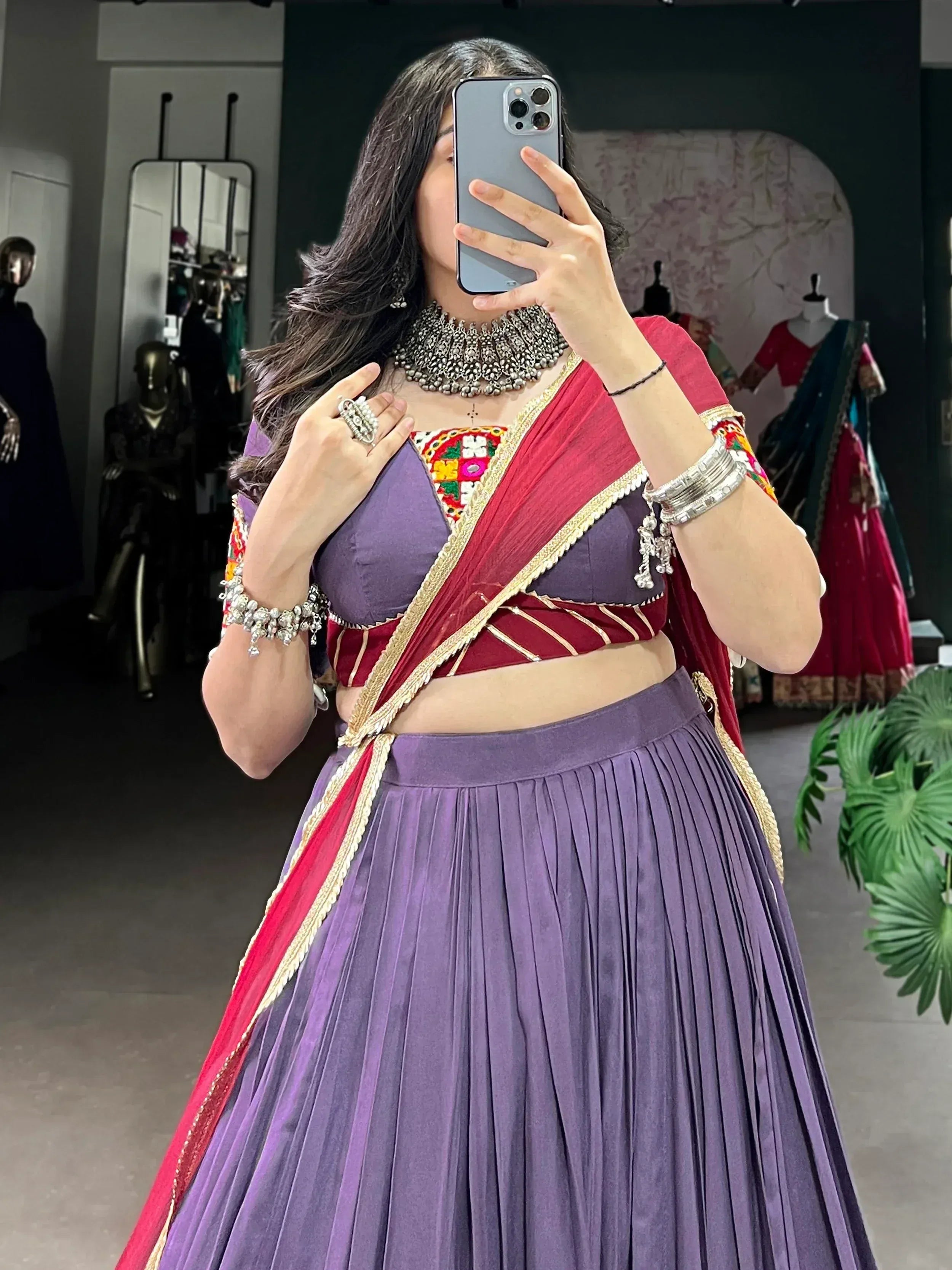 Purple and maroon lehenga choli with embroidered blouse, gold trim, and traditional jewelry for Indian ethnic wear