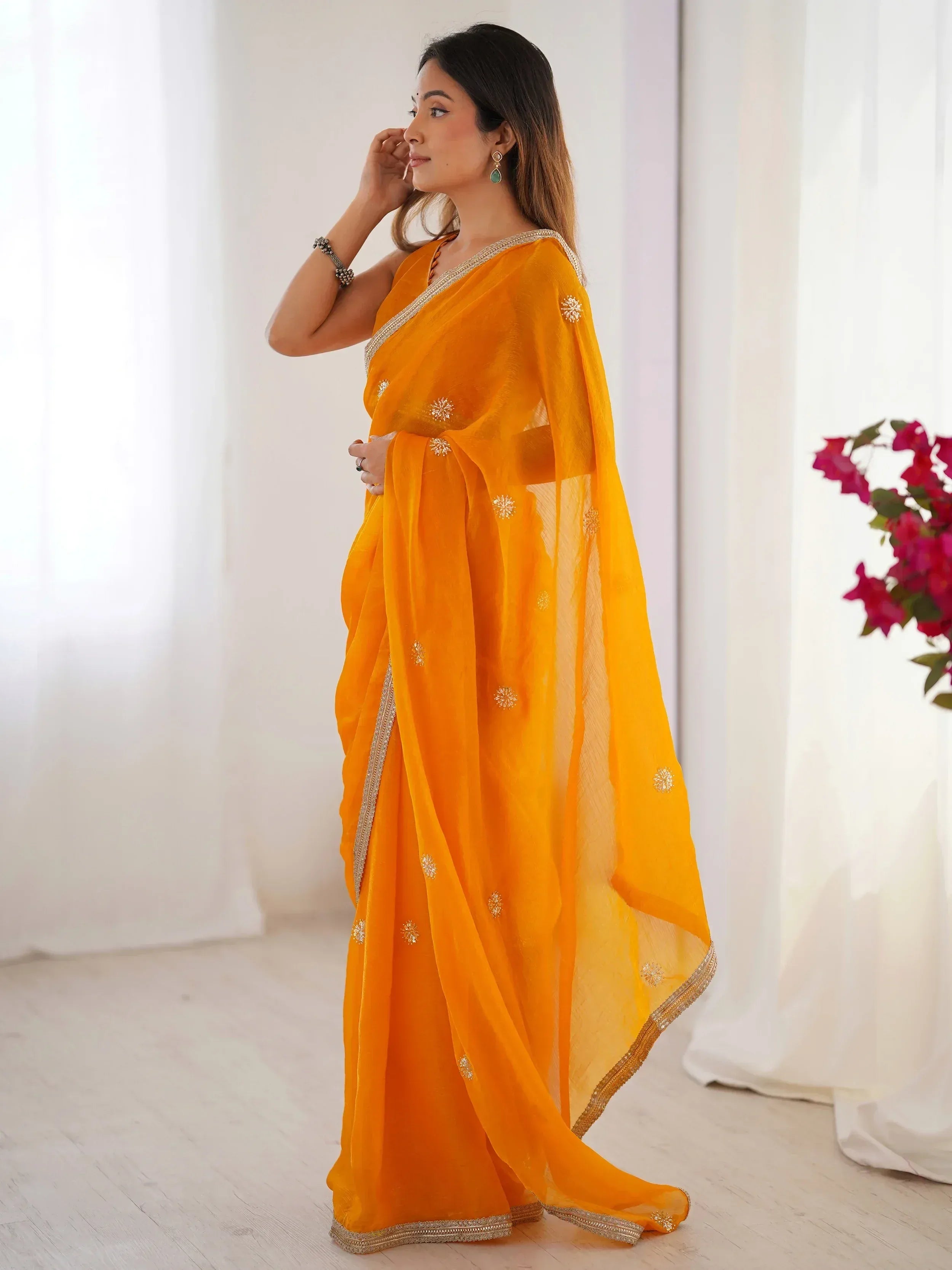 Vibrant orange ethnic saree with gold embroidery, perfect for Indian occasions and festive wear.
