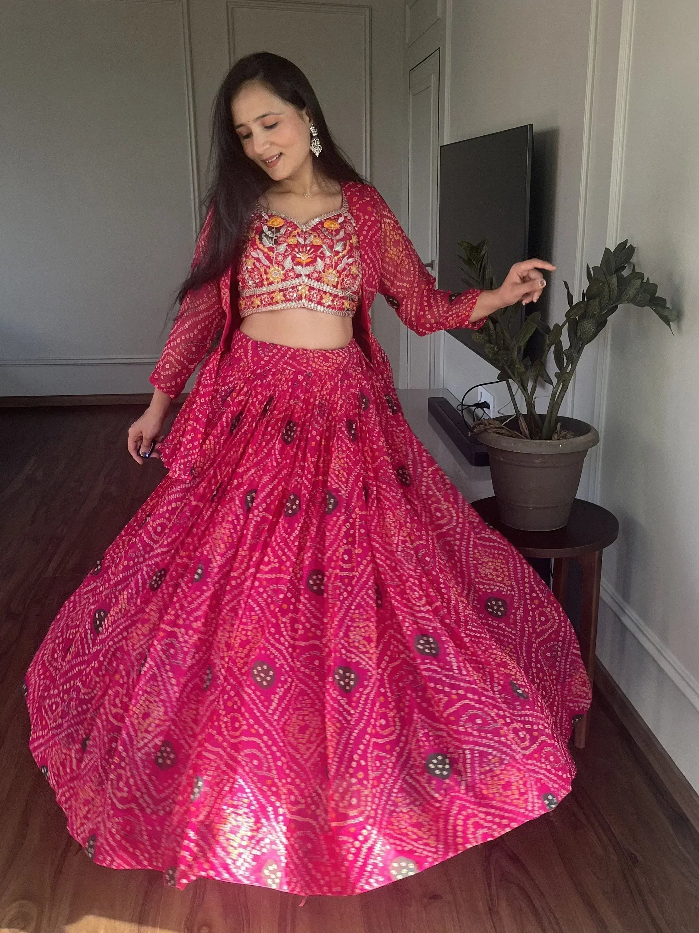 Woman in vibrant pink embroidered lehenga choli with floral blouse, perfect for Indian ethnic wear occasions
