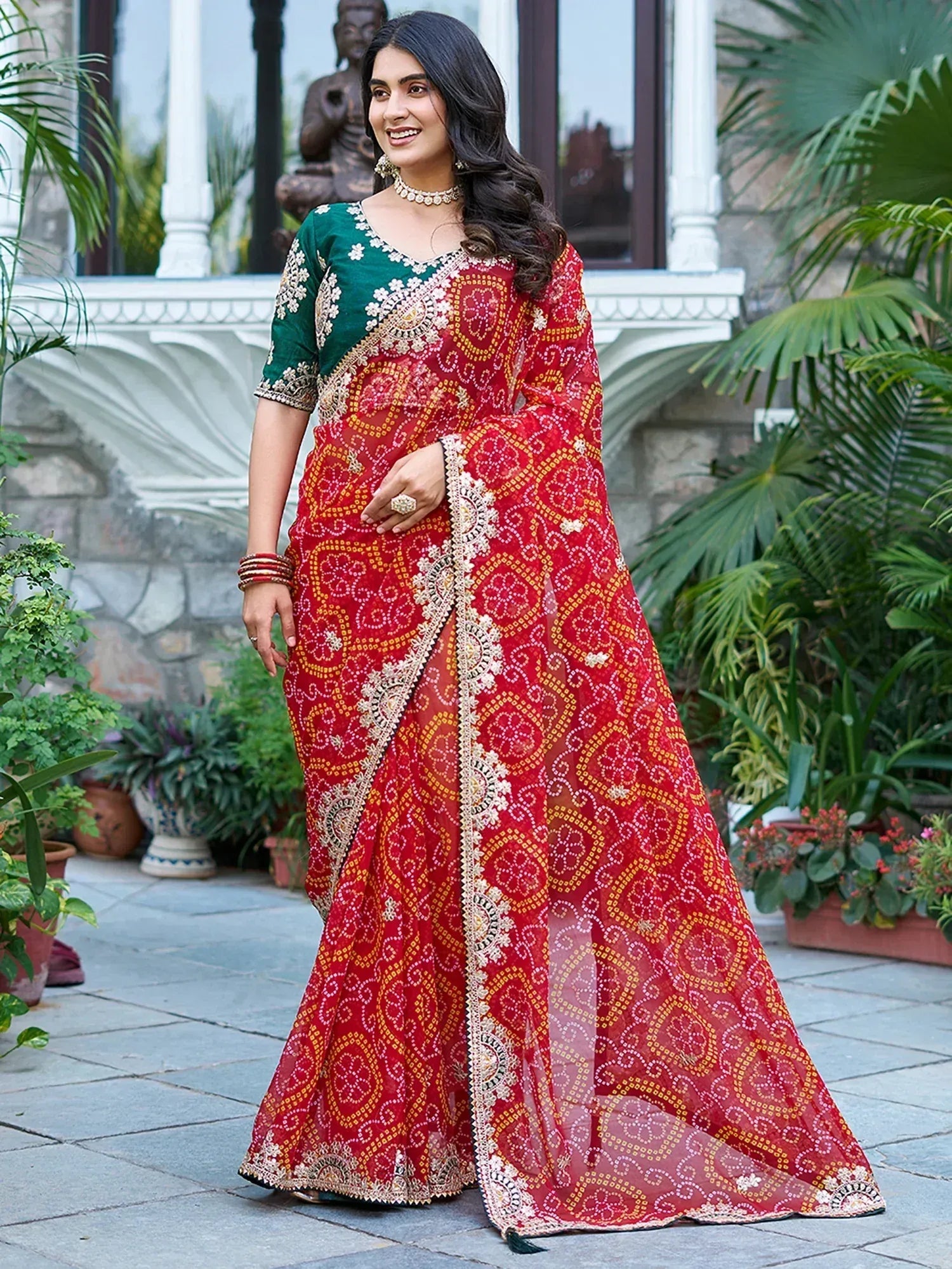 Woman in red printed saree with green blouse, ethnic Indian wear, floral embroidery, garden setting