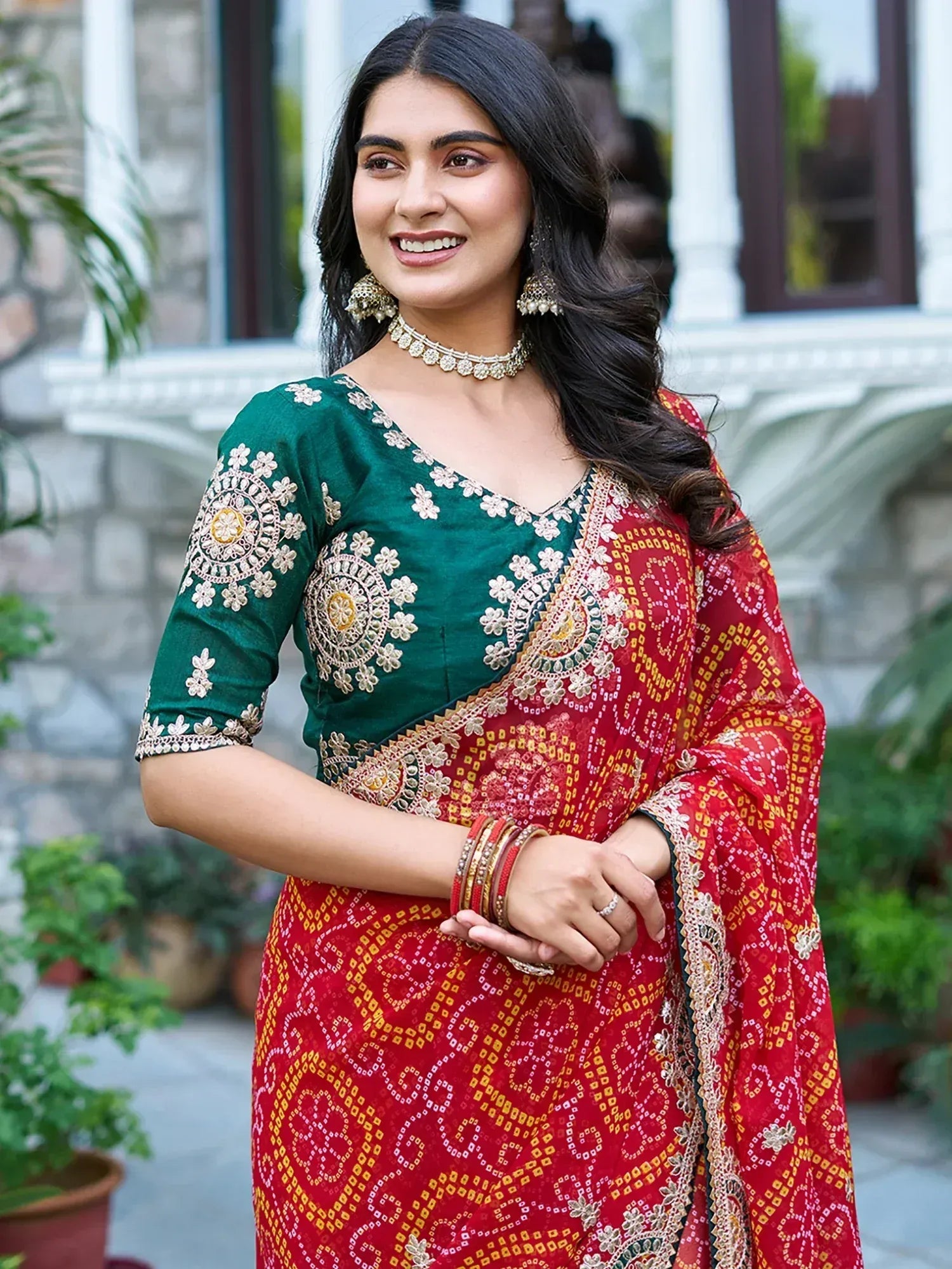 Woman in red and green embroidered saree with floral blouse, traditional Indian ethnic wear