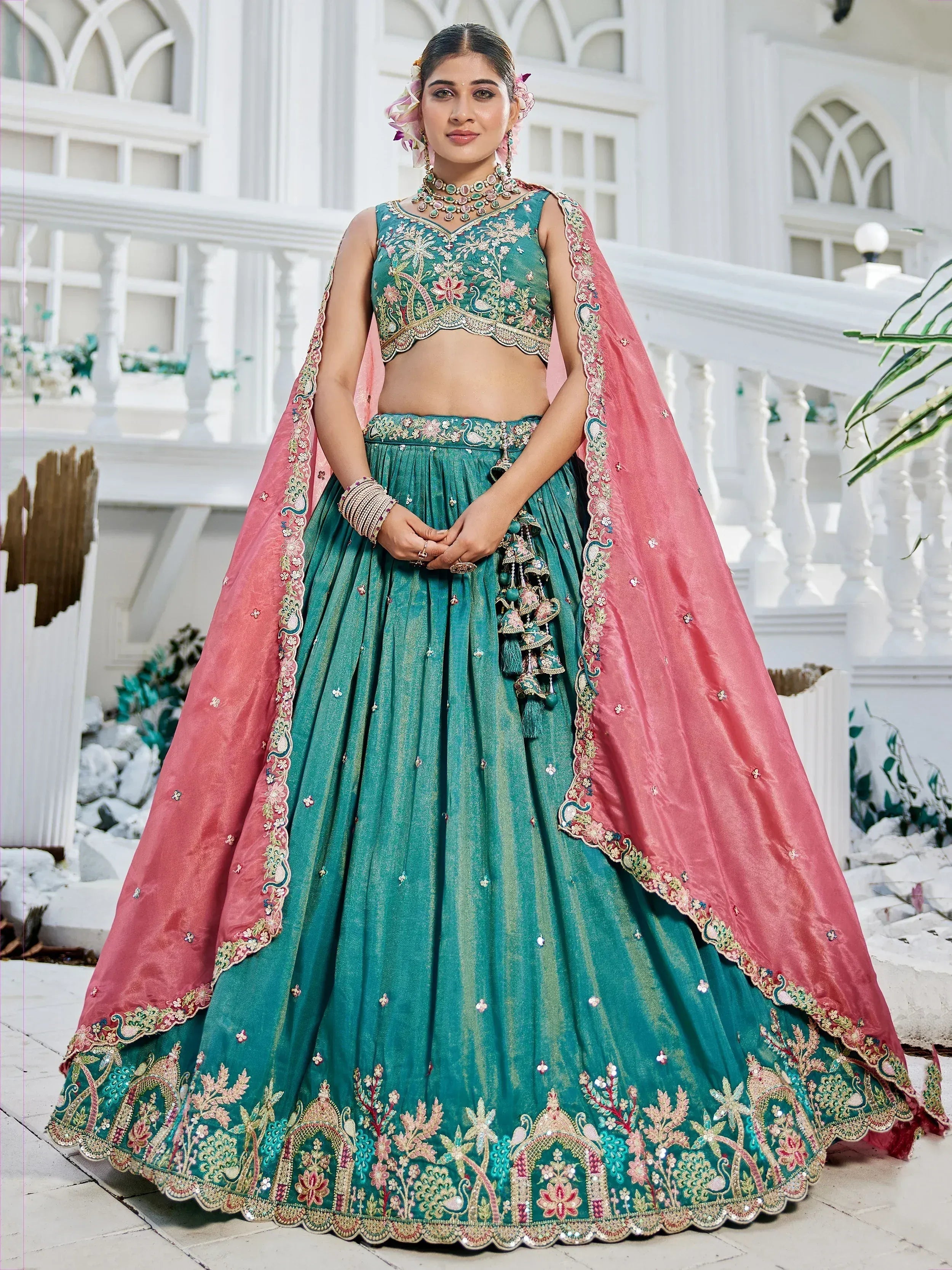 Teal embroidered lehenga choli with pink dupatta, floral motifs, and peacock design for Indian ethnic wear