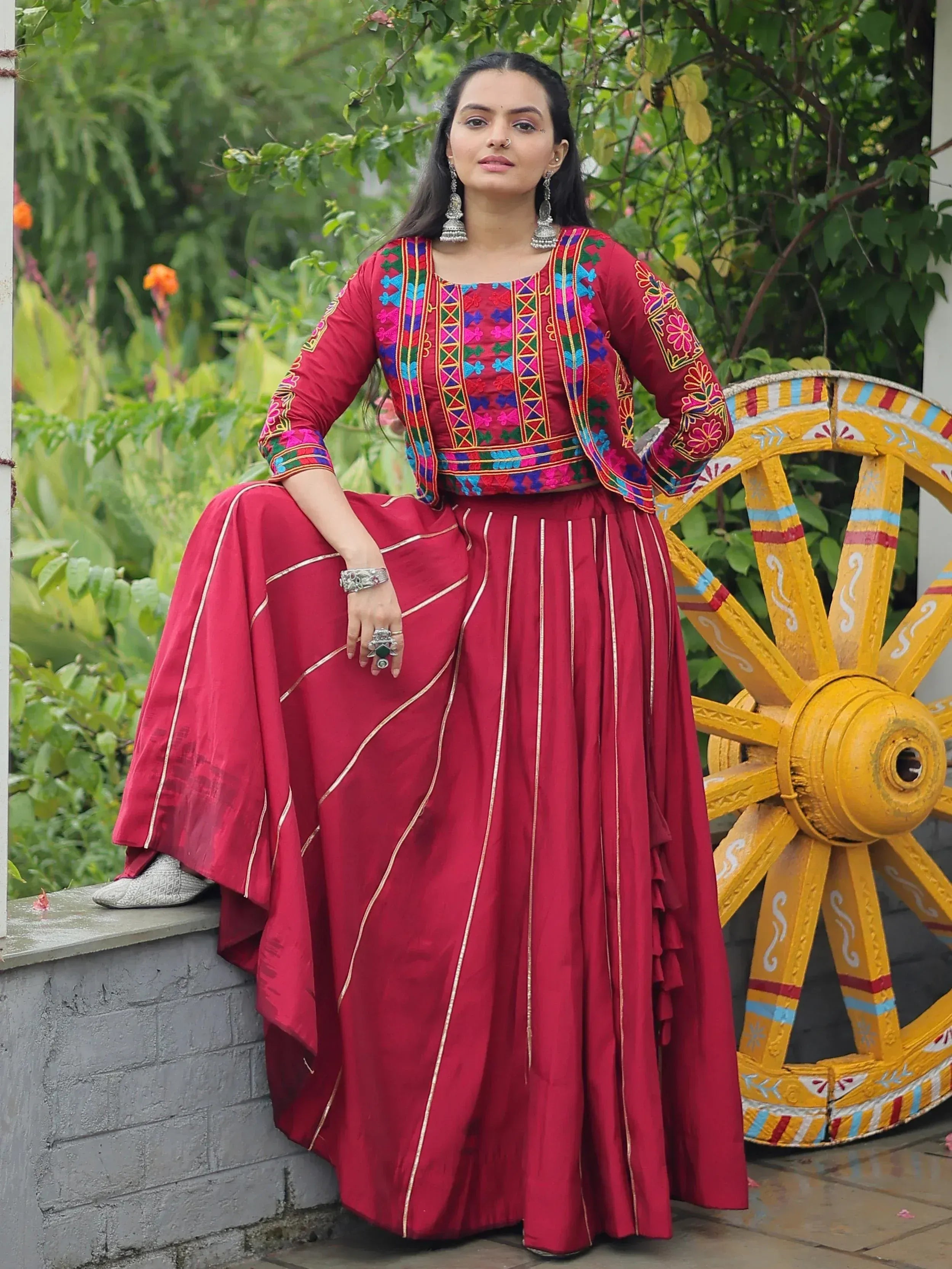 Red embroidered Indian ethnic wear with colorful blouse and skirt, perfect for festive occasions