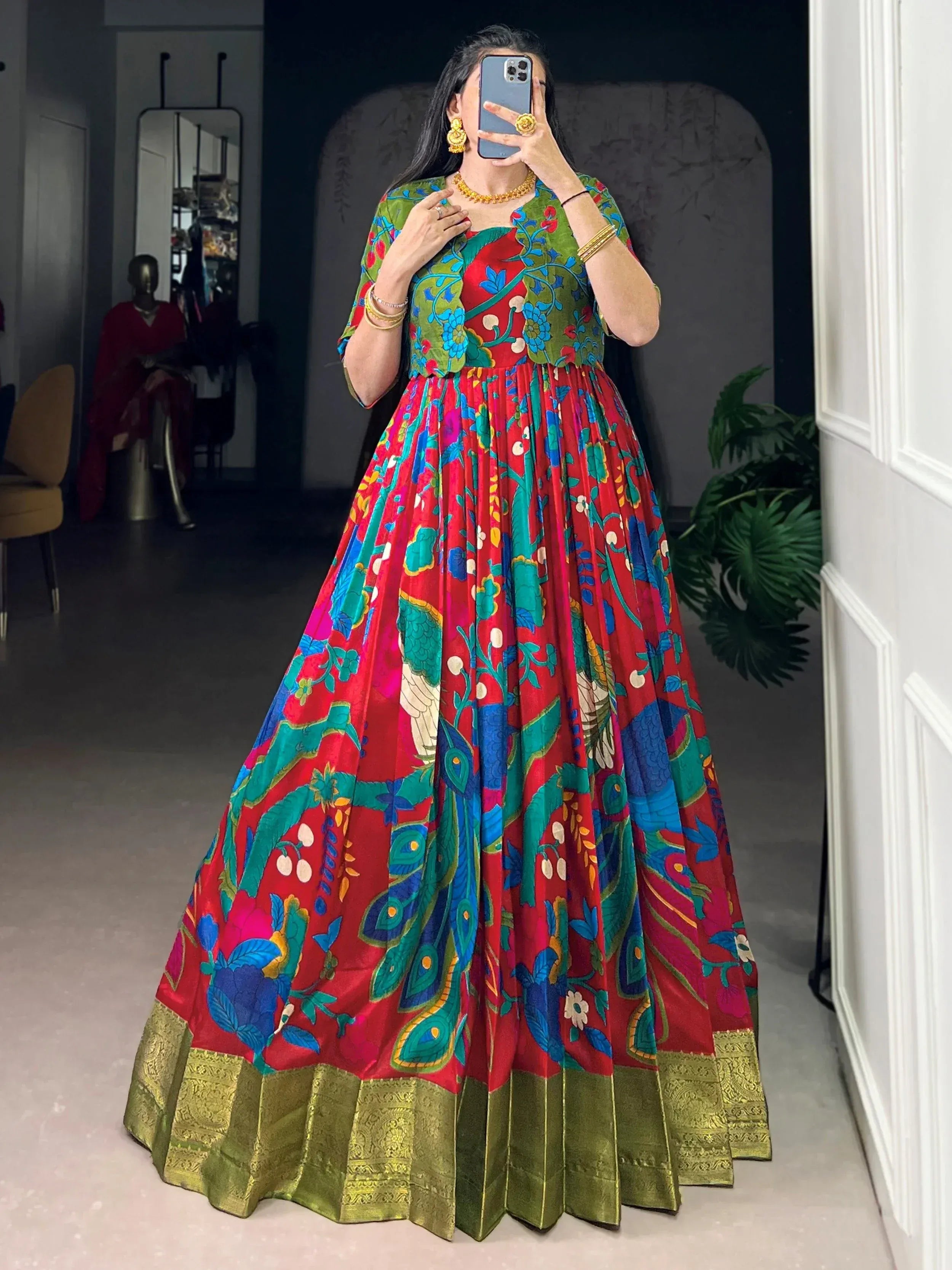 Vibrant red and green floral ethnic gown with peacock print, perfect for festive occasions.