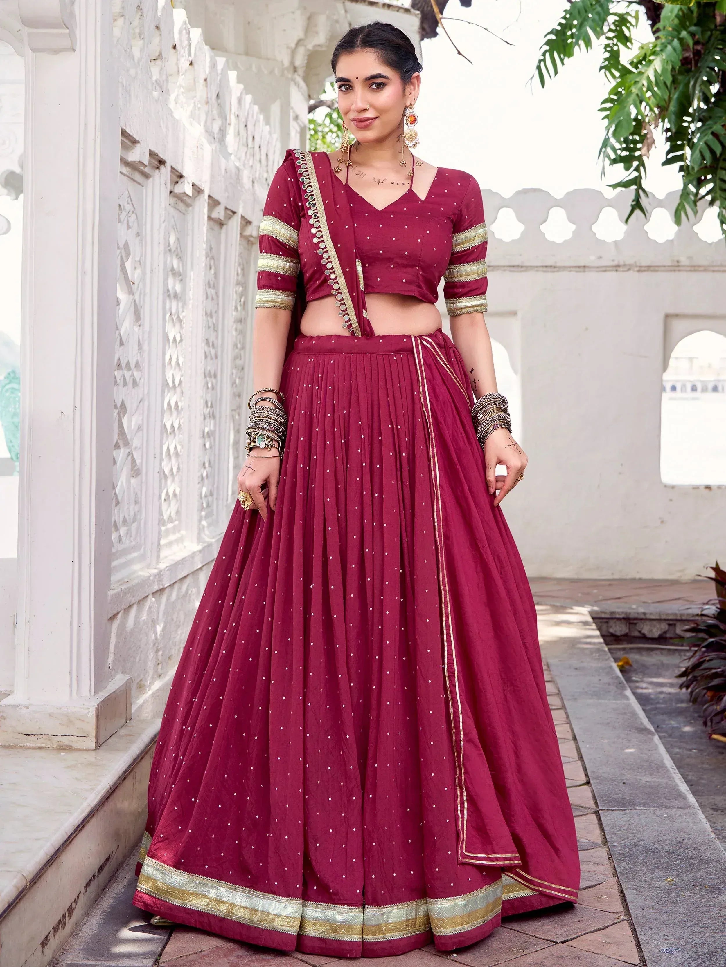 Maroon designer lehenga choli with gold trim, perfect for Indian ethnic wear and festive occasions.