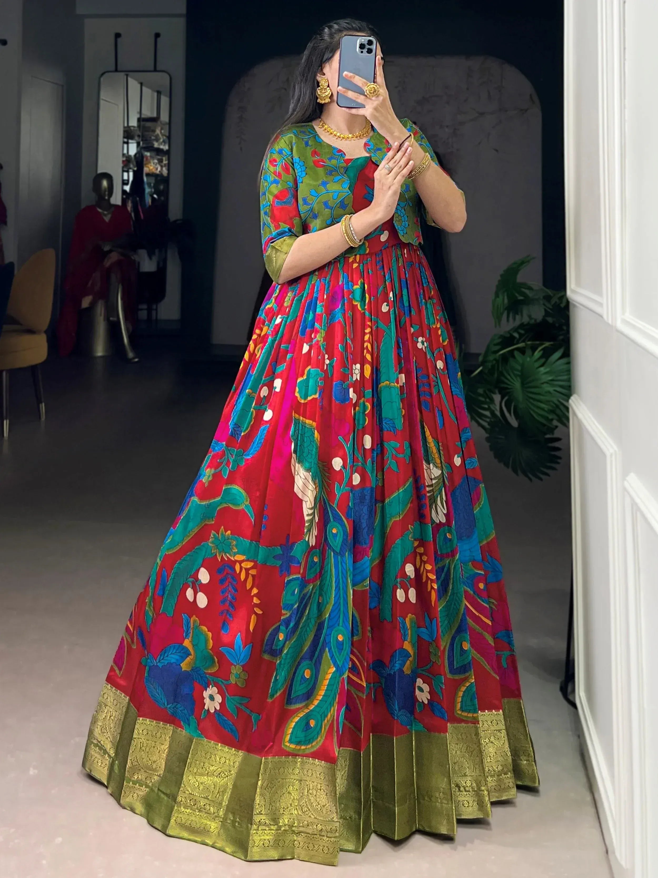 Vibrant red and green floral print ethnic gown with peacock motifs and golden border
